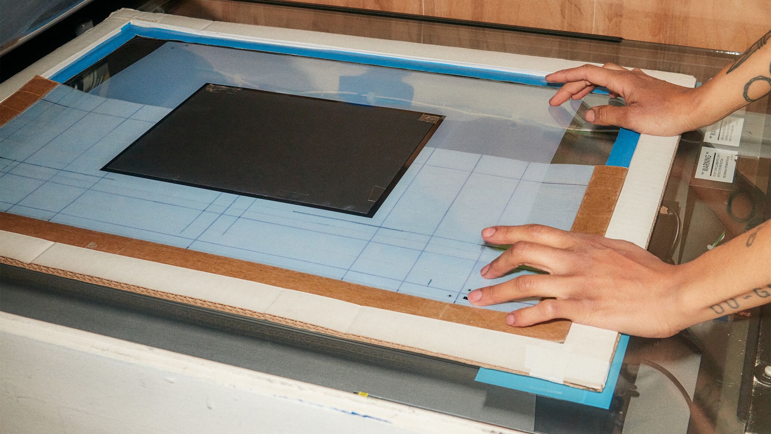 A photograph of Diuguid adjusting the registration of a film by Rafael Rios, dated 2022.