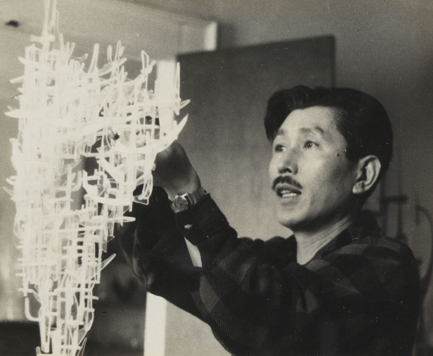 A photo of Leo Amino completing a construction in polystyrene at his Watts Street apartment studio in Greenwich Village, dated 1958.