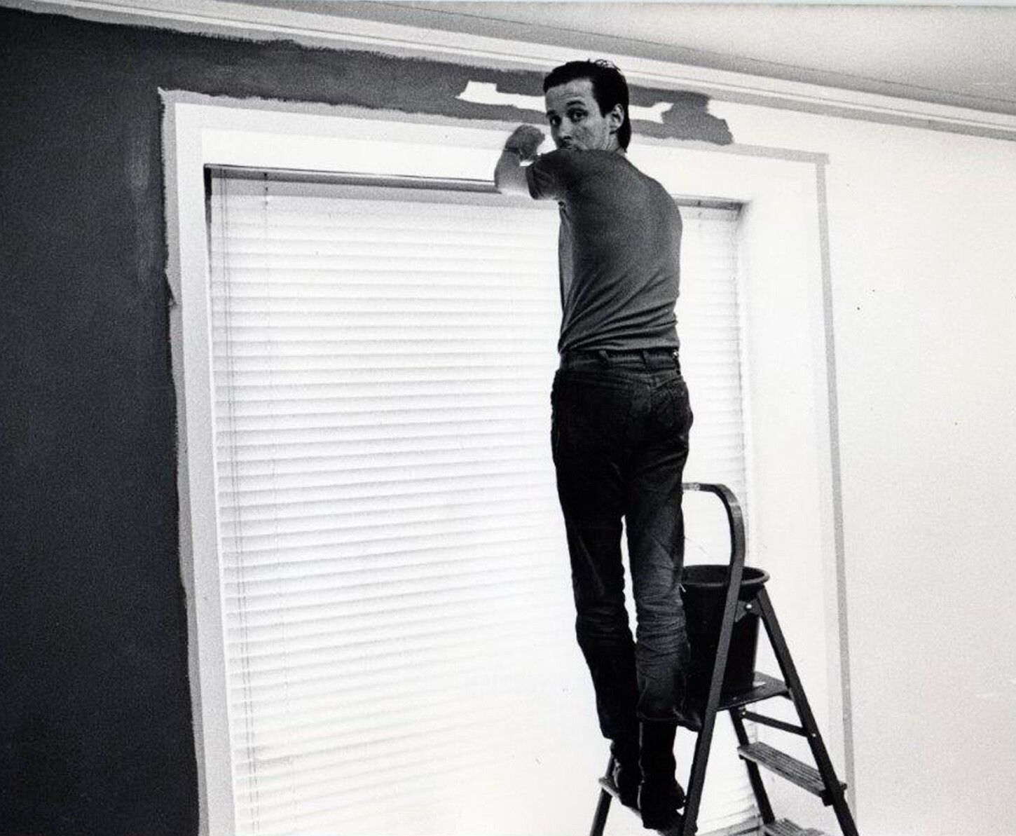 A photo of Palermo painting a wall at Galerie Heiner Friedrich, Cologne, April 1971.