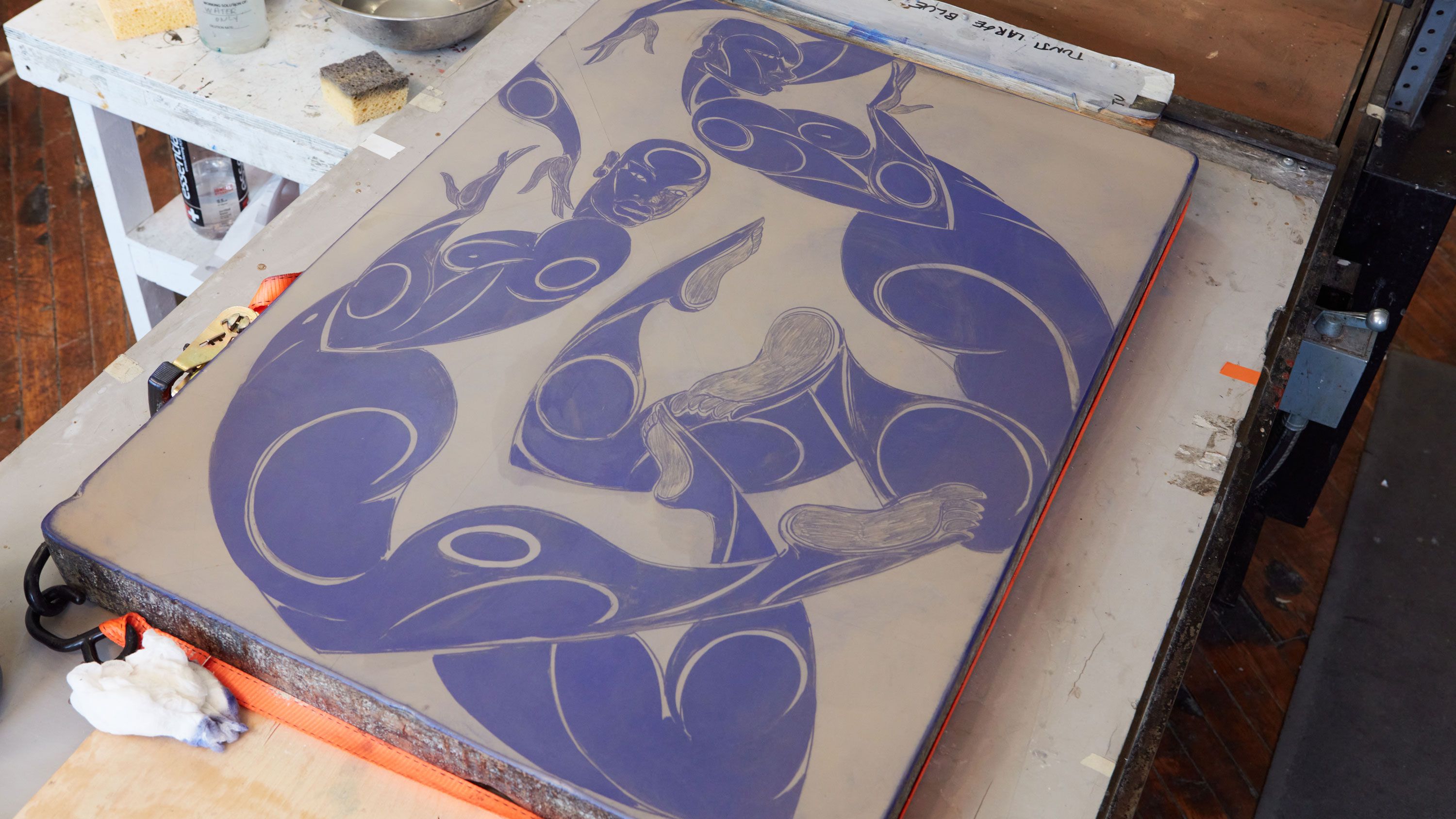 A photograph featuring a stone panel with two figures curled up floating on the surface in purple color, photo by Rafael Rios