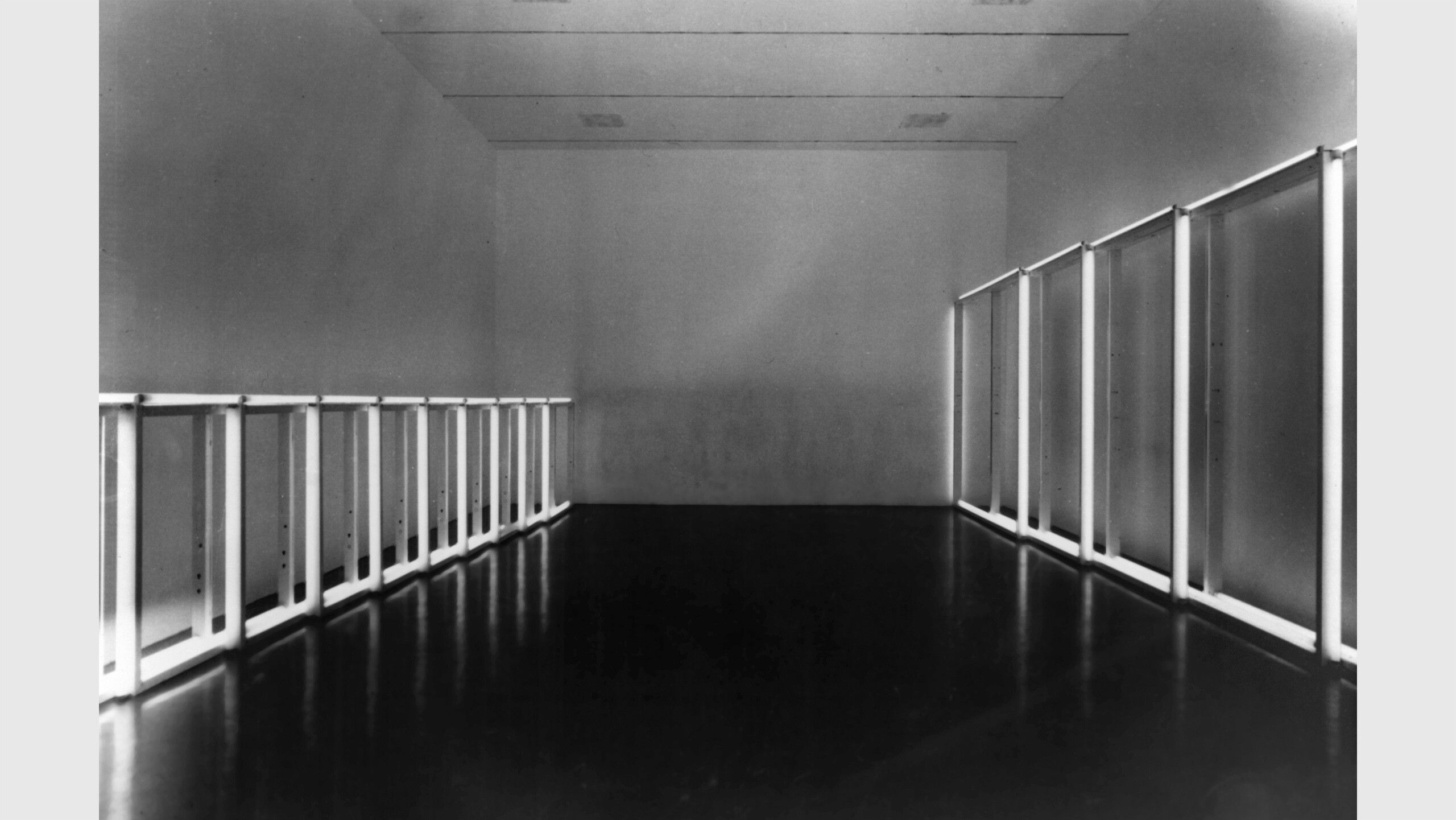 This is a black and white photo of an installation view from the exhibition titled SPACES at MoMA in 1969, featuring Dan Flavin's fluorescent light Untitled