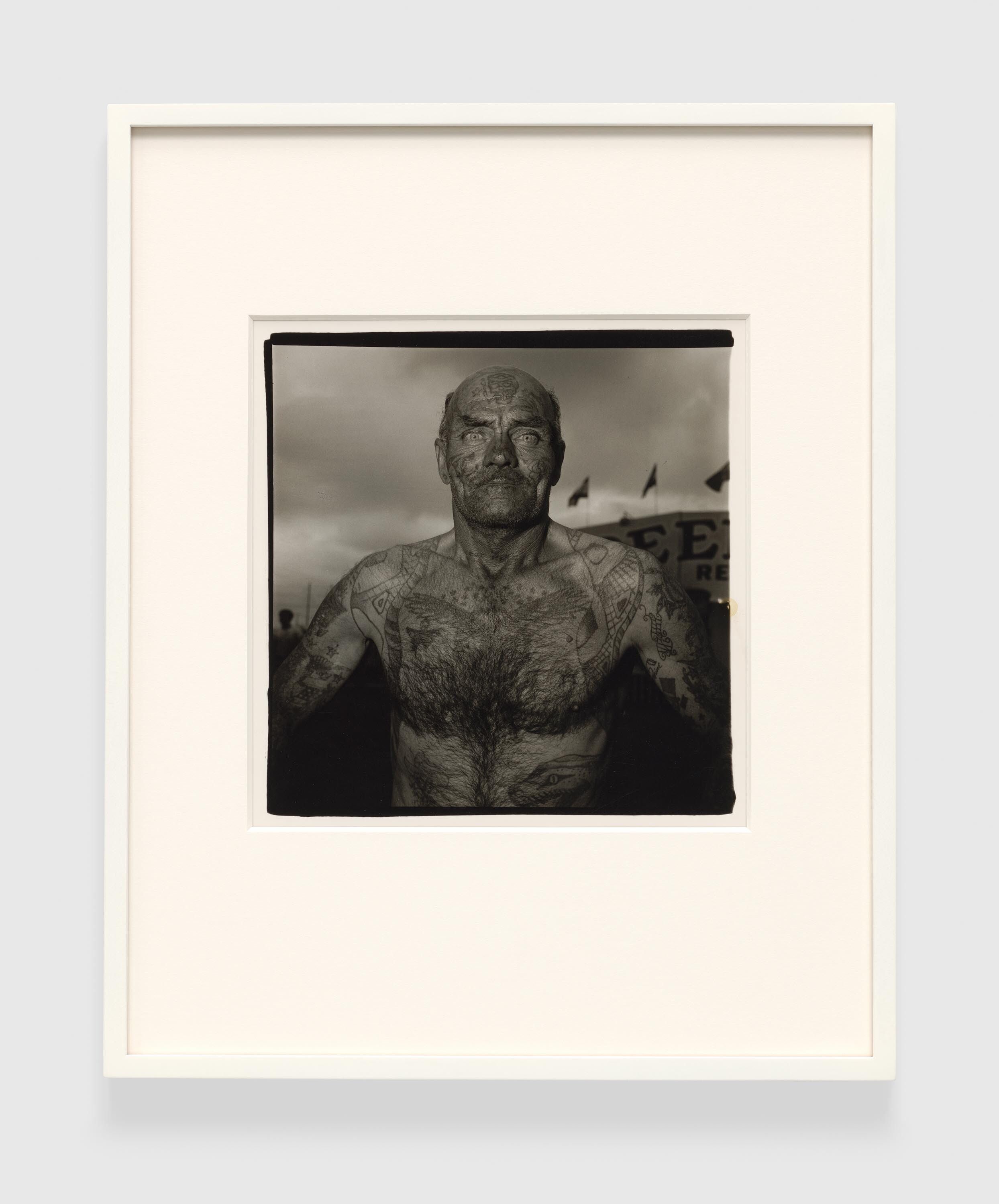 A gelatin silver print by Diane Arbus, titled Tattooed man at a carnival, MD. 1970, dated 1970.