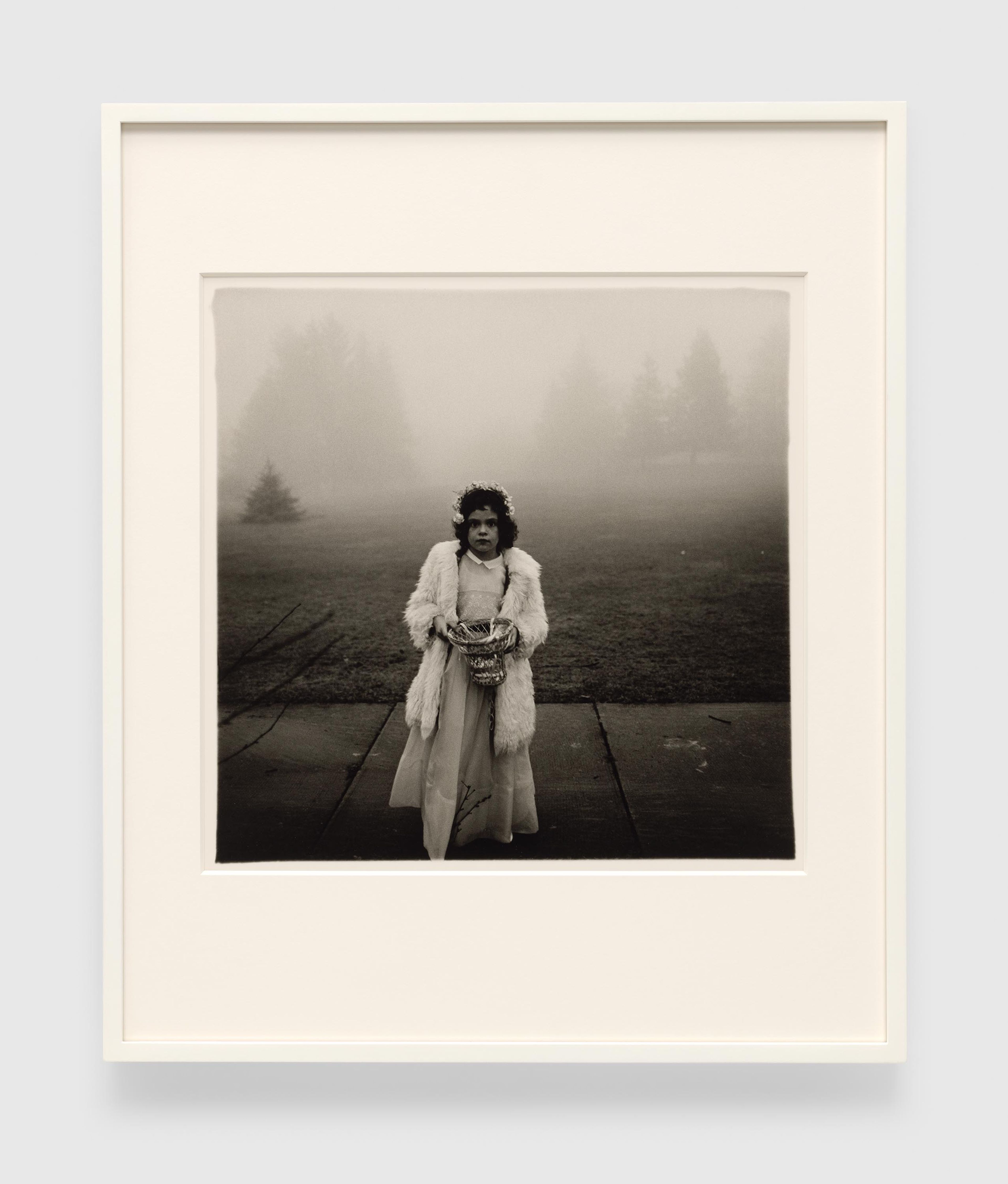 A gelatin silver print by Diane Arbus, titled A flower girl at a wedding, Conn. 1964, dated 1964.