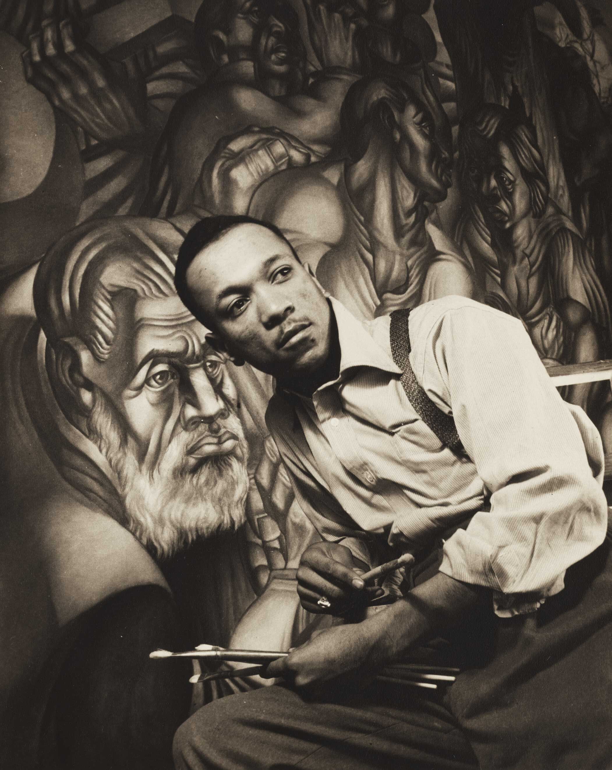 A photograph of Charles White Charles White in front of a work titled Struggle for Liberation. Photo by Gordon Parks, dated c. 1940-1941