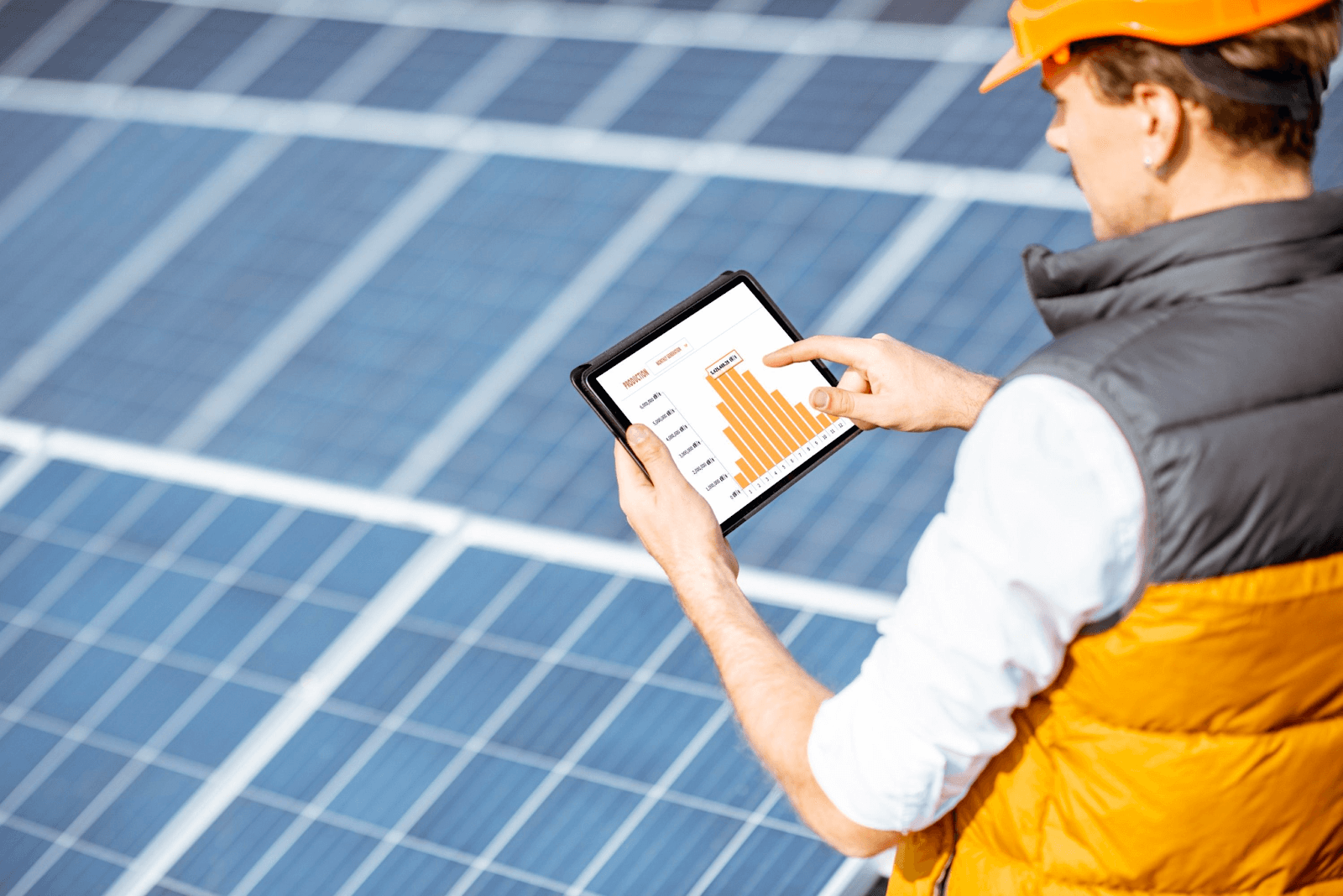 man looking at a solar panel monitoring system on his tablet