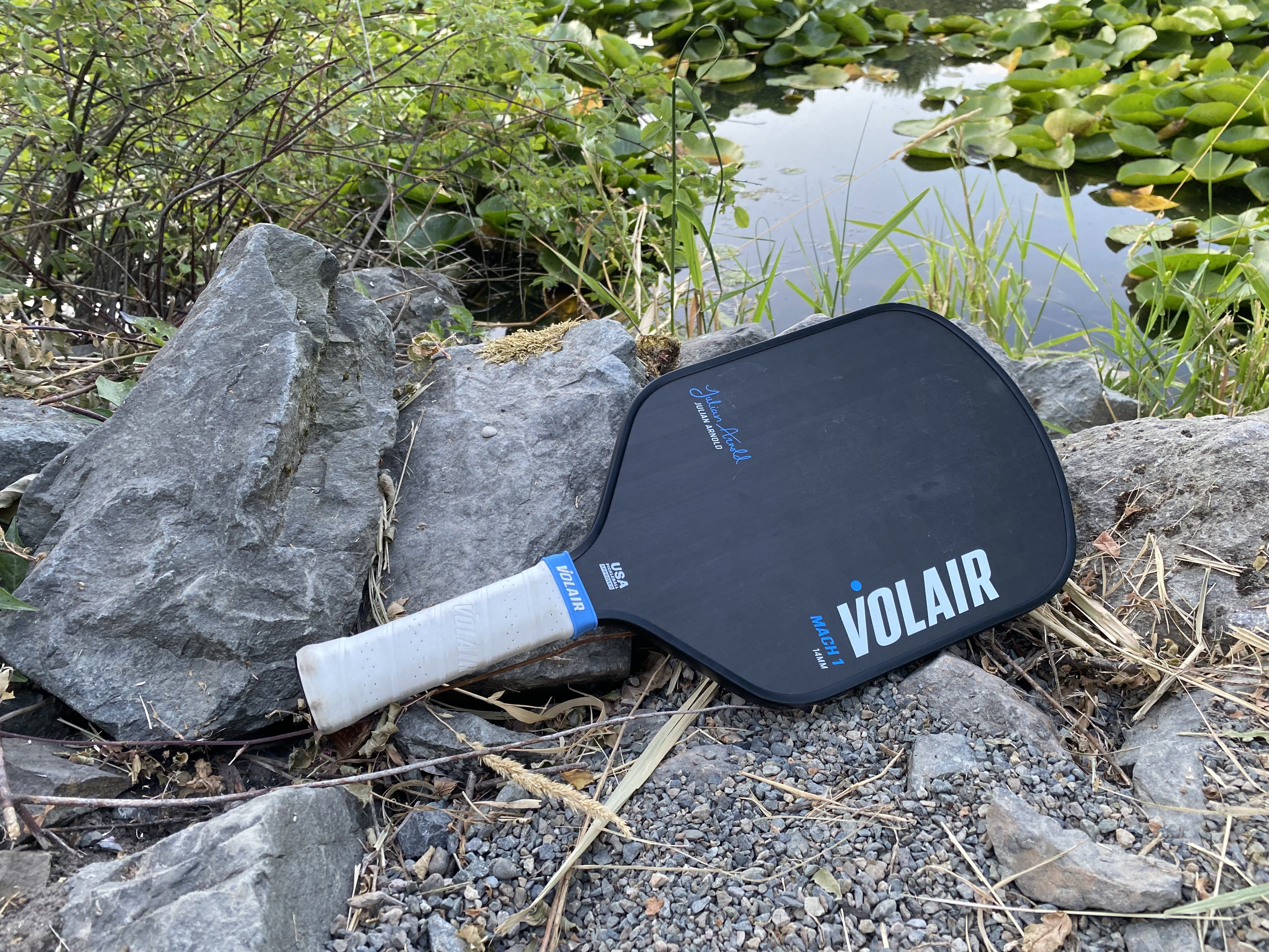 The Volair Mach 1 pickleball paddle resting against a rock