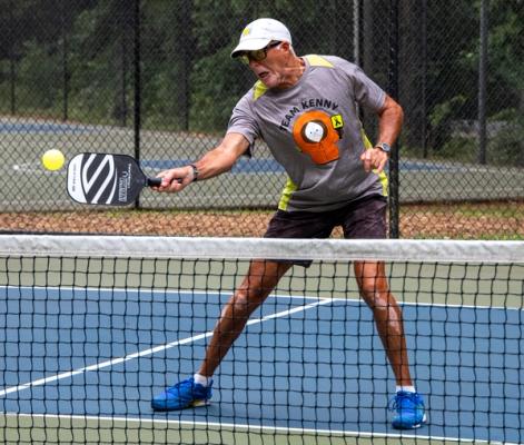 Pickleball player wearing a team name shirt during a game