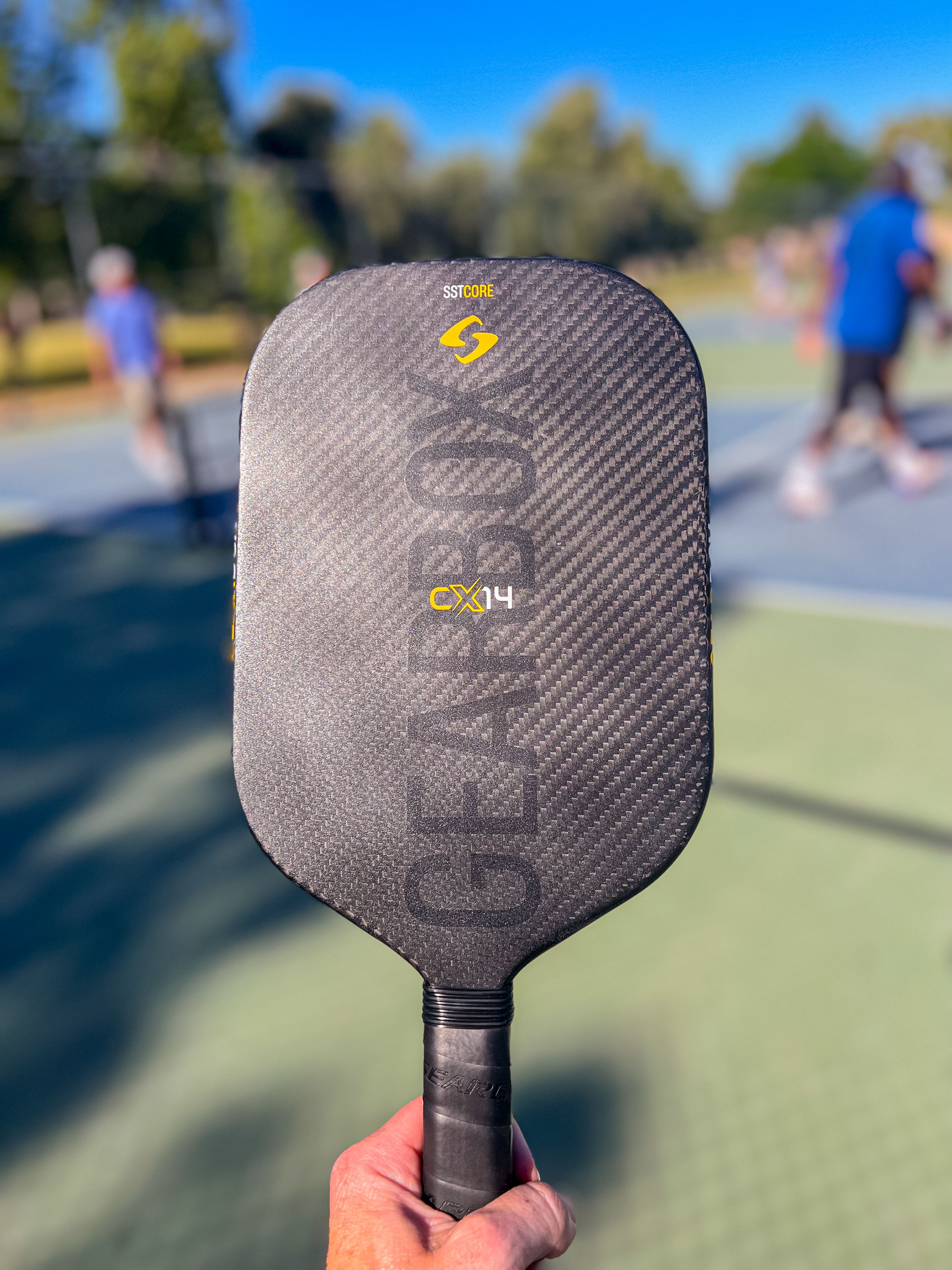 Brandon Mackie holds out the Gearbox CX14E pickleball paddle