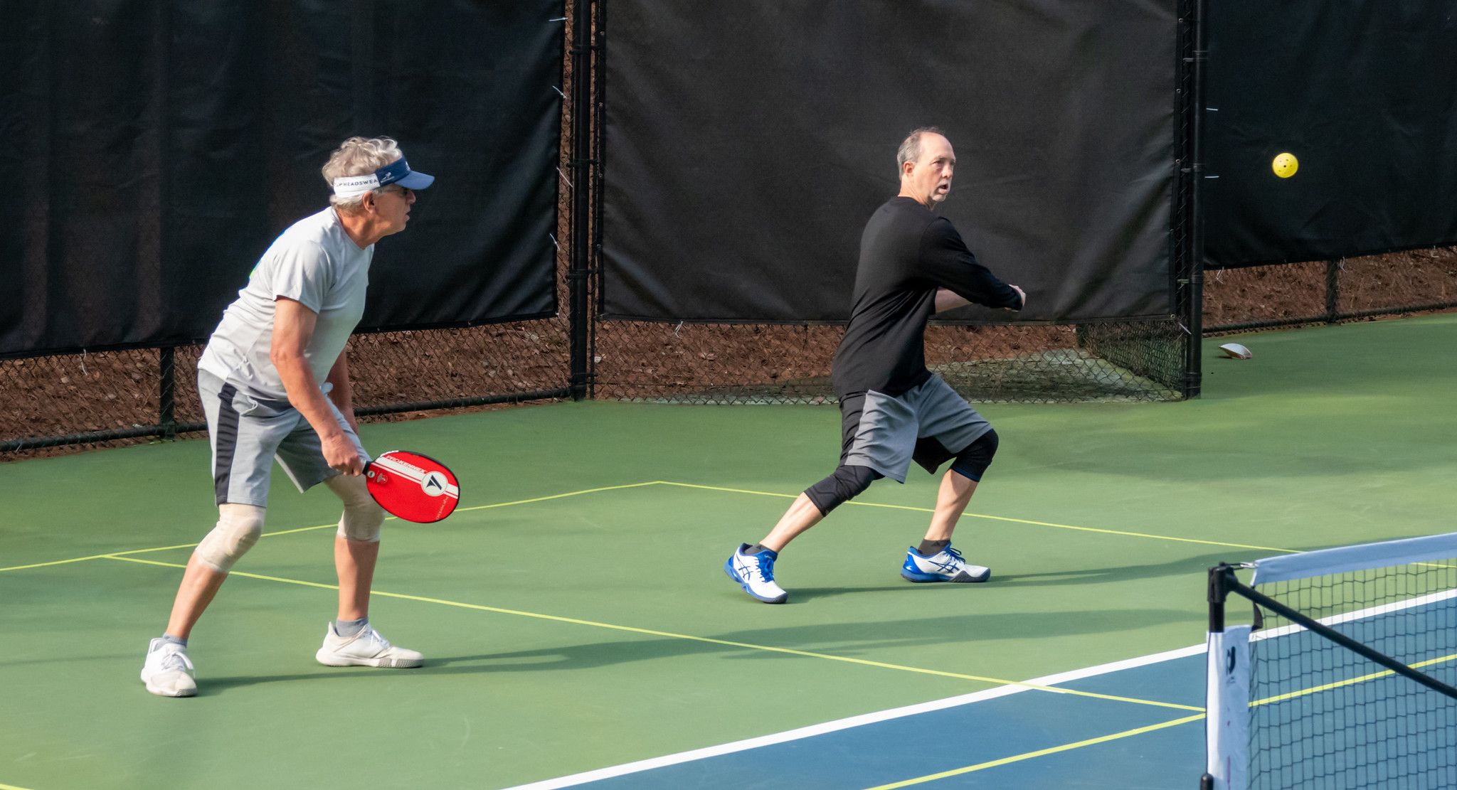 two men playing pickleball doubles