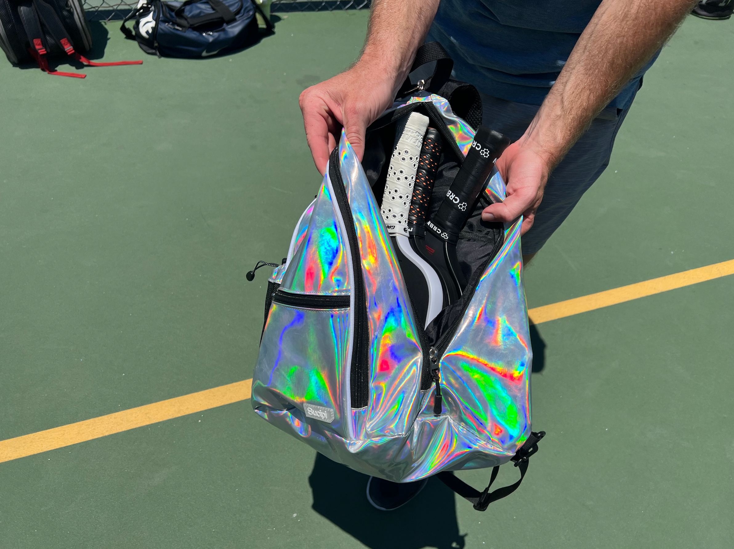 Brandon Mackie showing off the storage space in the Sucipi Pickleball Backpack