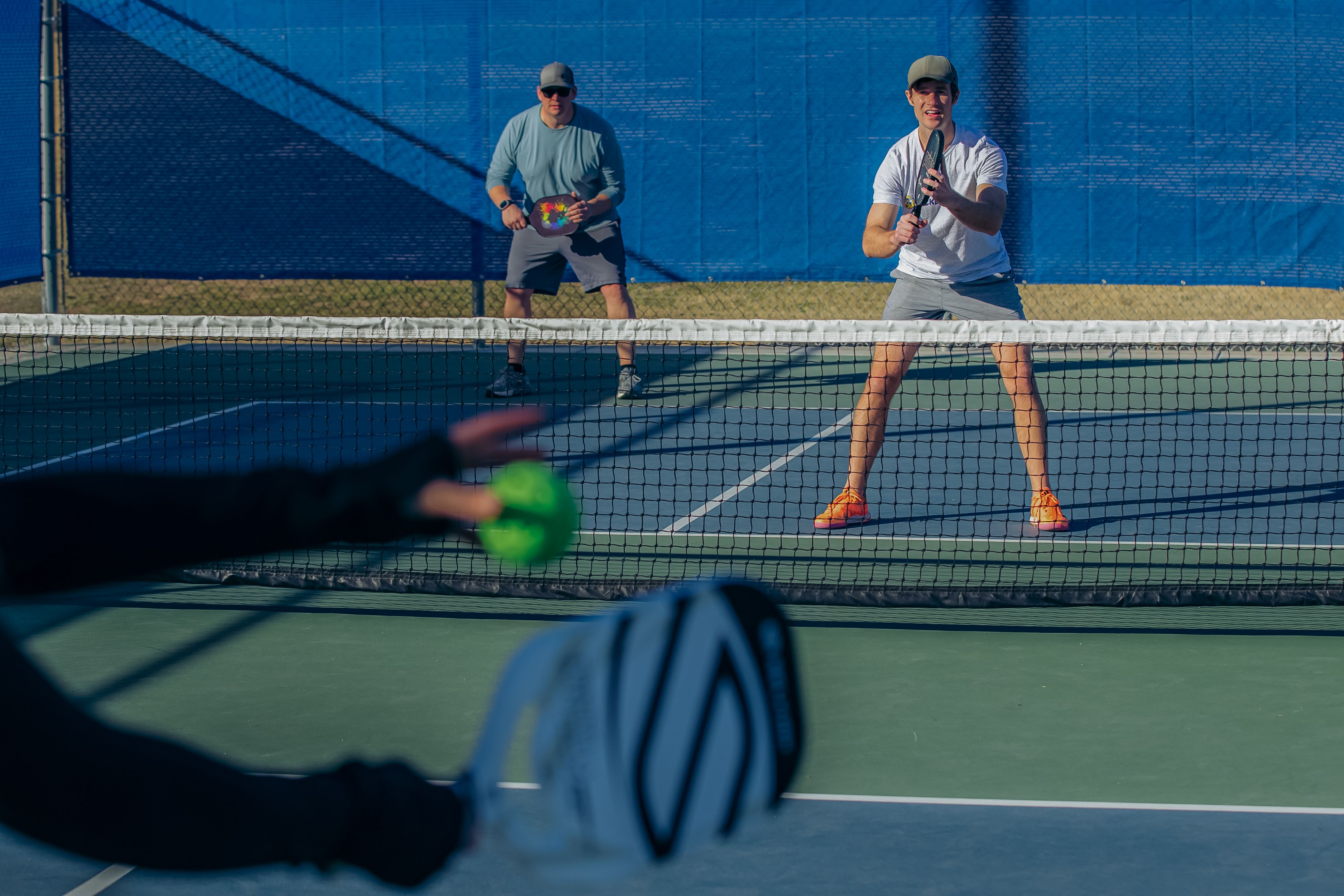 Pickleball player serves as the other team prepares to return it