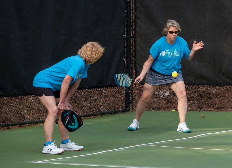 Two players in the middle of a game of doubles pickleball at an open play session