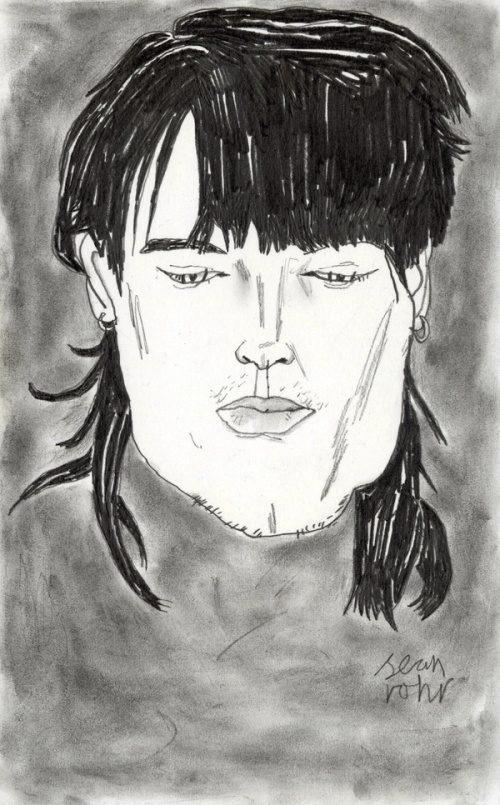 Portrait of a young man with dark hair looking down