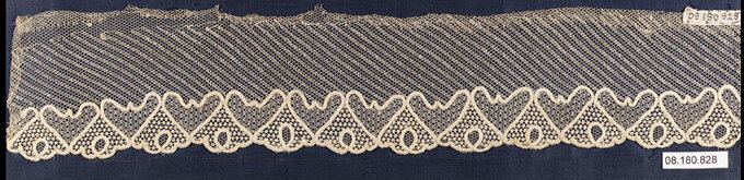 A strip of fine net whose even mesh runs in diagonal bands, with a scalloped border of heart-shaped motifs filled with smaller net patterns along the lower edge, on a dark blue mount.