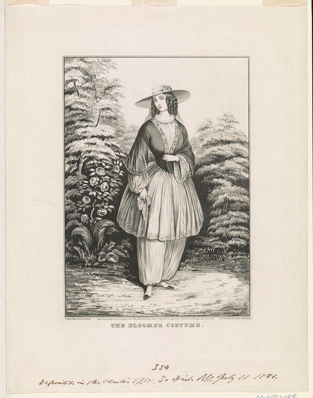 A black-and-white lithograph of a young woman standing in a garden in a wide-brimmed hat, an open dark jacket with wide, gathered sleeves over a pale blouse, and a knee-length flared tunic above full trousers gathered at the ankles, holding a handkerchief; the title The Bloomer Costume is printed beneath.