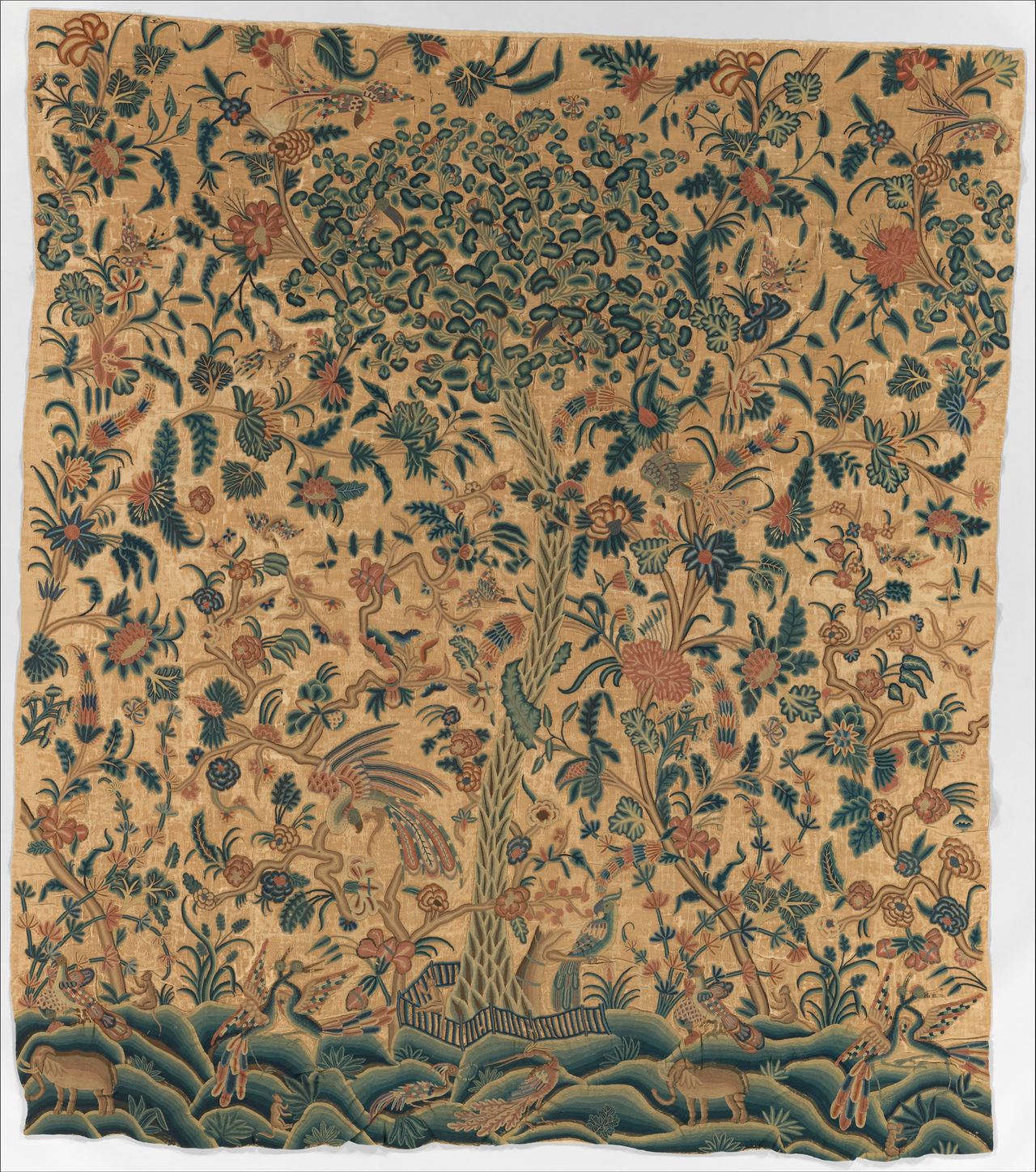 A bed hanging covered in embroidered foliage on a tan ground: a central tree with a dense crown, curling branches, large flowers, birds, and animals on green hillocks at the bottom.