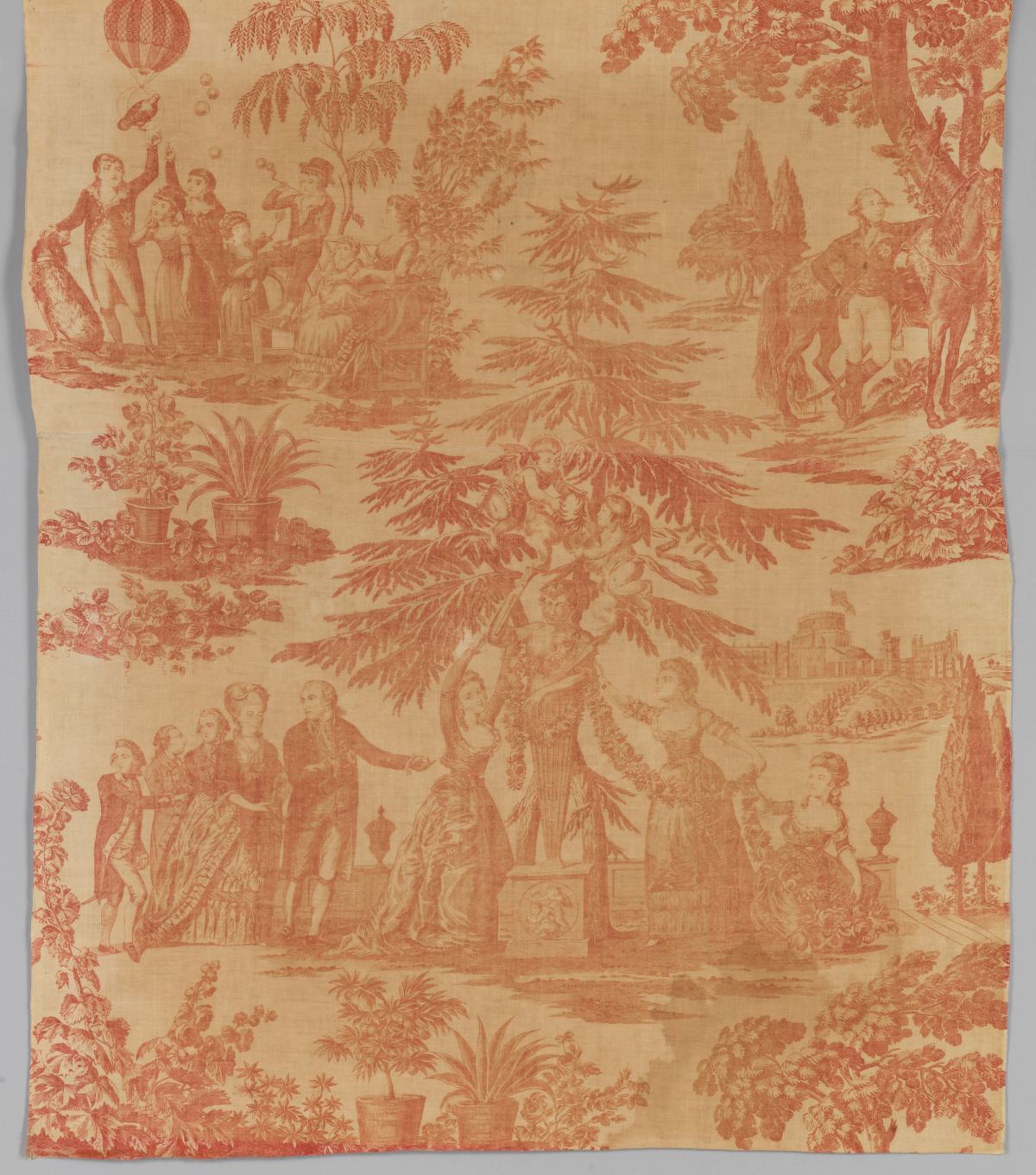 A length of cotton printed in a single red-brown colour with a scene of a family group by a statue under a large conifer, a hot-air balloon at upper left and a castle at right.