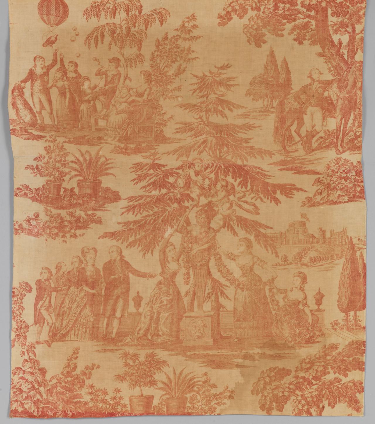 A length of cotton printed in a single red-brown colour with a scene of a family group by a statue under a large conifer, a hot-air balloon at upper left and a castle at right.