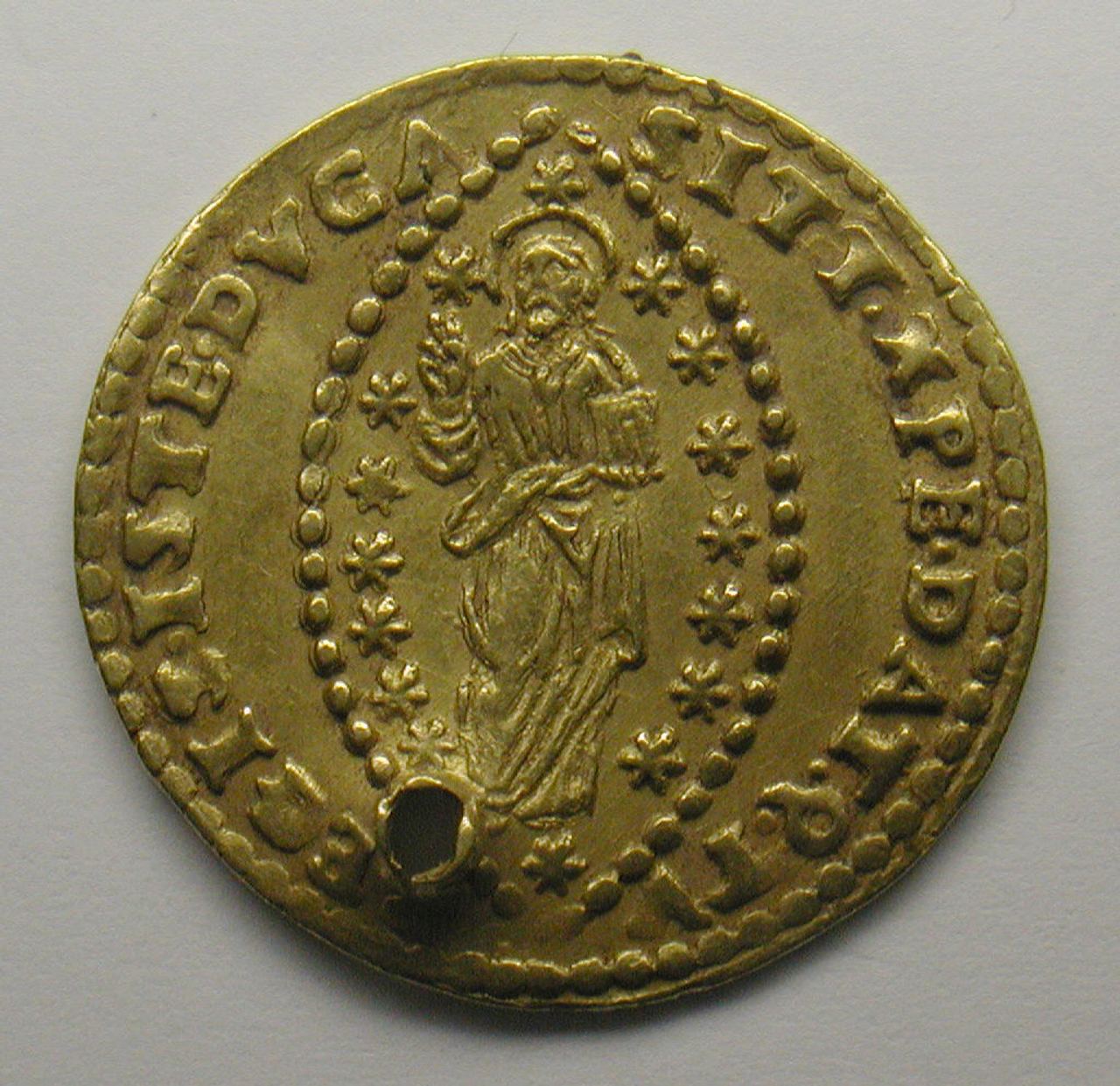 A small gold Venetian zecchino, one side showing a standing figure of Christ inside an oval of beads and stars, with lettering around the rim and a round hole pierced through the edge near the bottom.