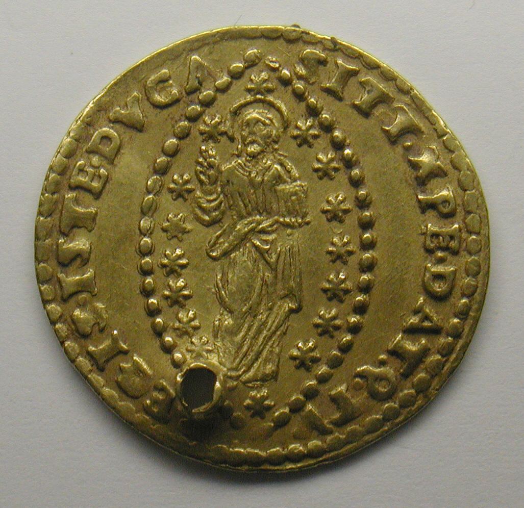 A small gold Venetian zecchino, one side showing a standing figure of Christ inside an oval of beads and stars, with lettering around the rim and a round hole pierced through the edge near the bottom.