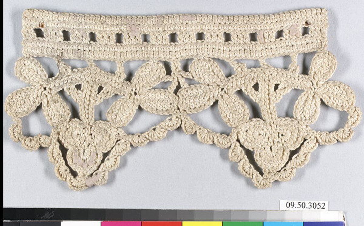 A cream-colored crochet border on a gray ground. A solid band along the top has a row of small square openings; below it hang leaf-like and trefoil motifs joined by scalloped loops, with a small looped edge.