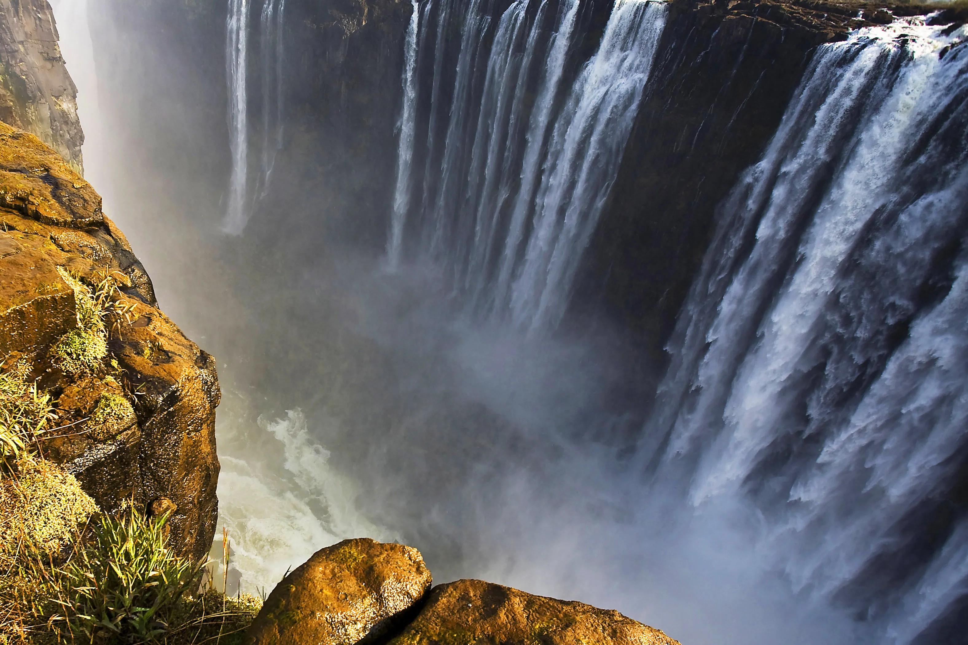View from the edge of Victoria Falls showing cascading water and rising mist between Zimbabwe and Zambia