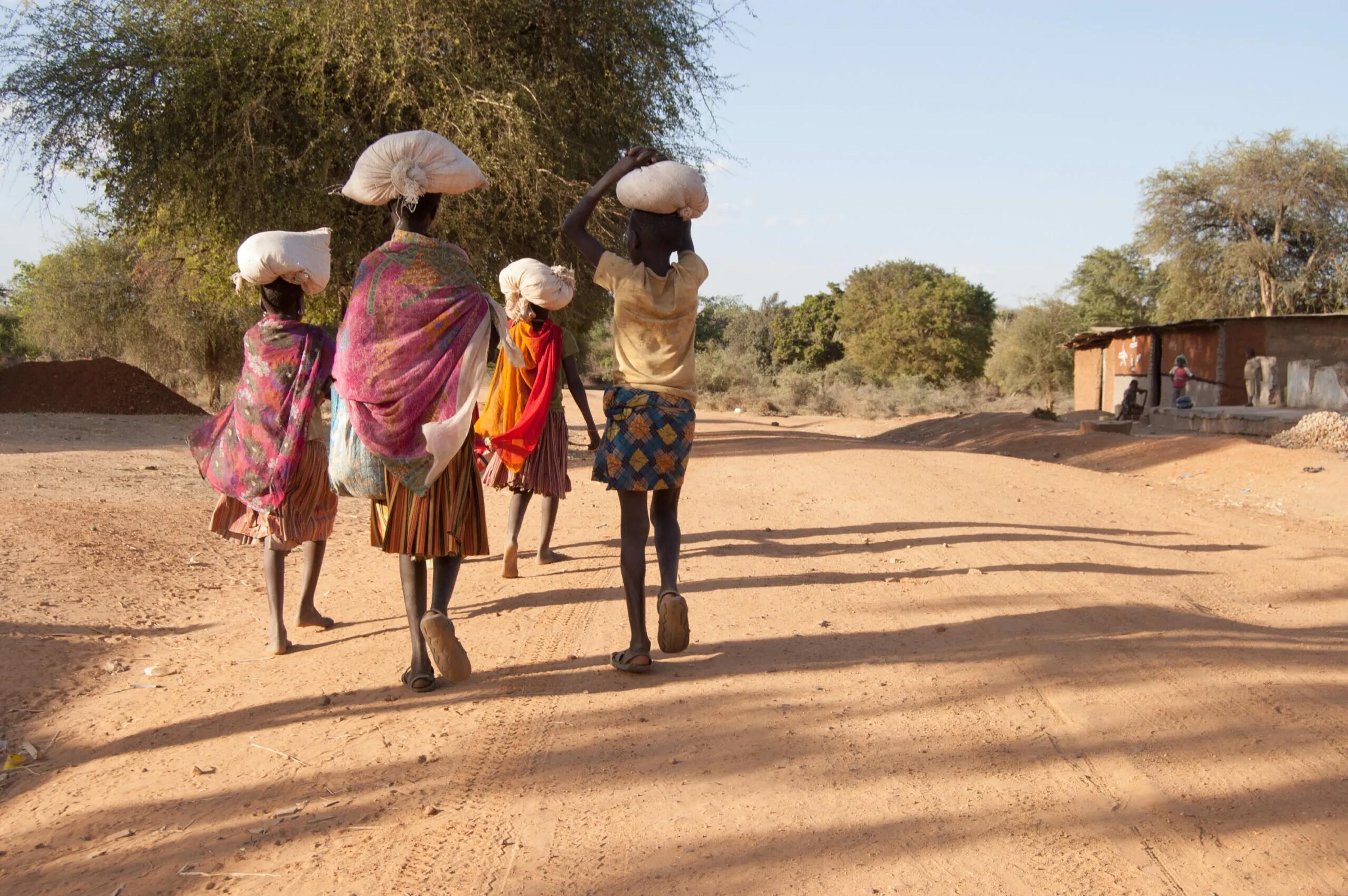 Afican People walking in a village with bag on their heads