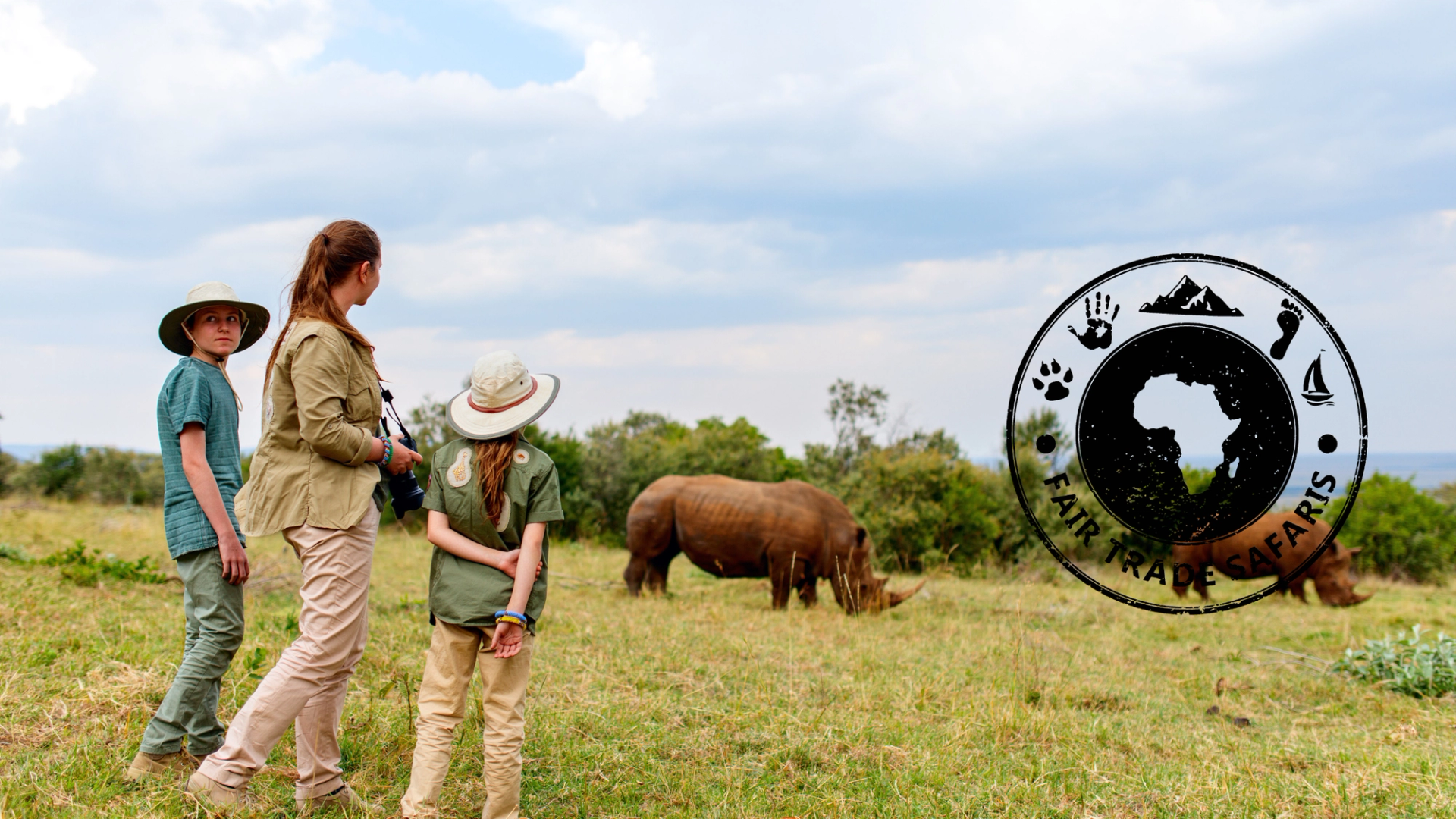 Woman and two children on safari observing a rhinoceros grazing in open grassland, with the Fair Trade Safaris logo displayed on the right.