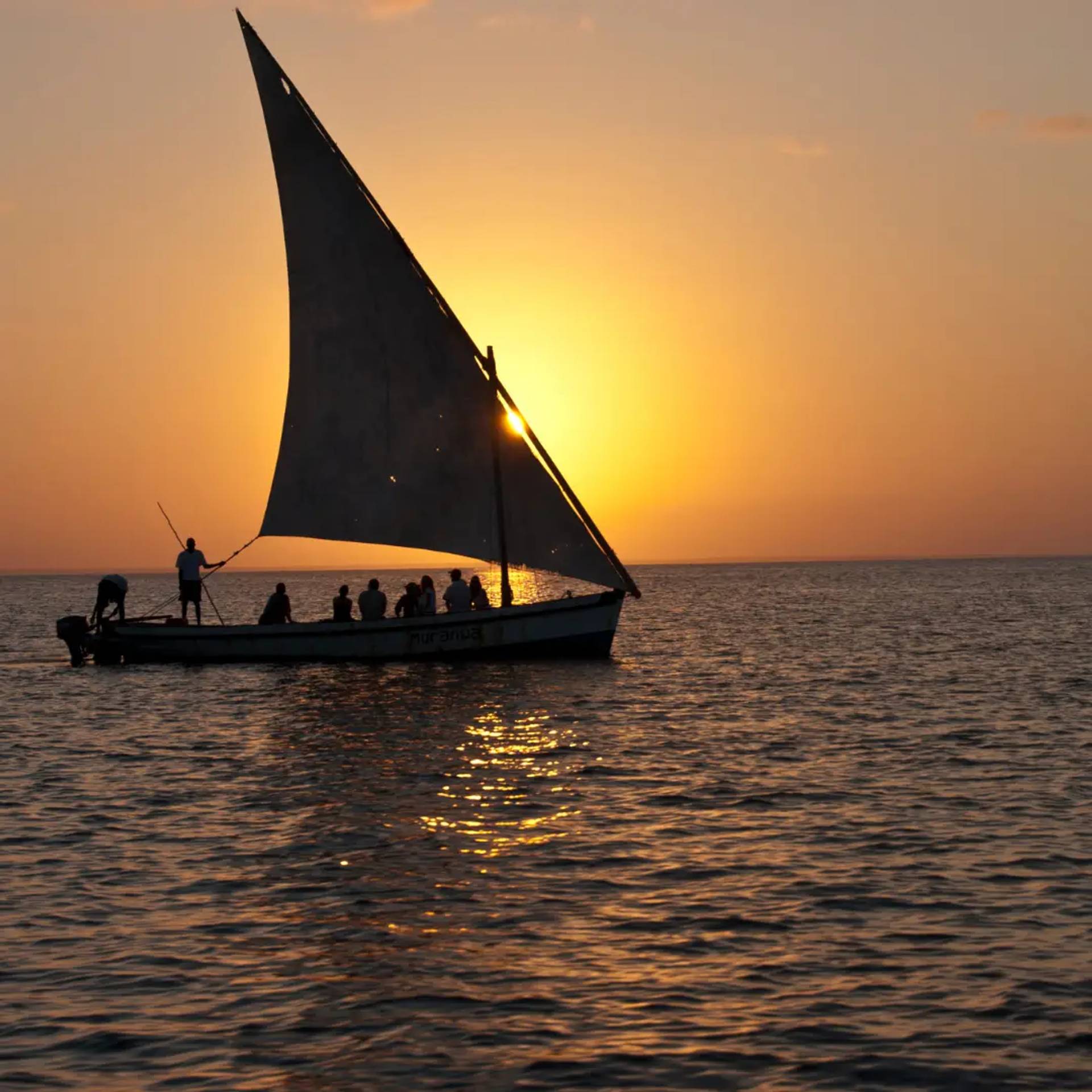 Traditional dhow sailing at sunset off the coast of Bazaruto Island, Mozambique