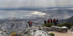 Travelers enjoying panoramic views over Cape Town and Table Bay from the summit of Table Mountain, South Africa