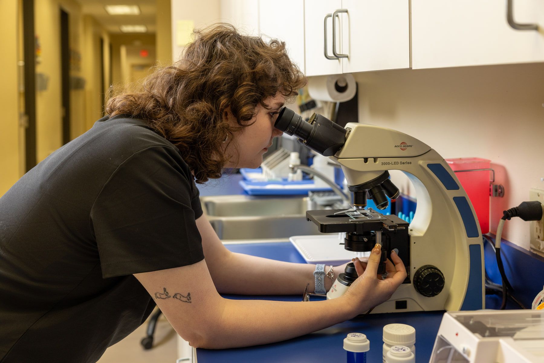 A technician looking through a microscope in the in-house laboratory