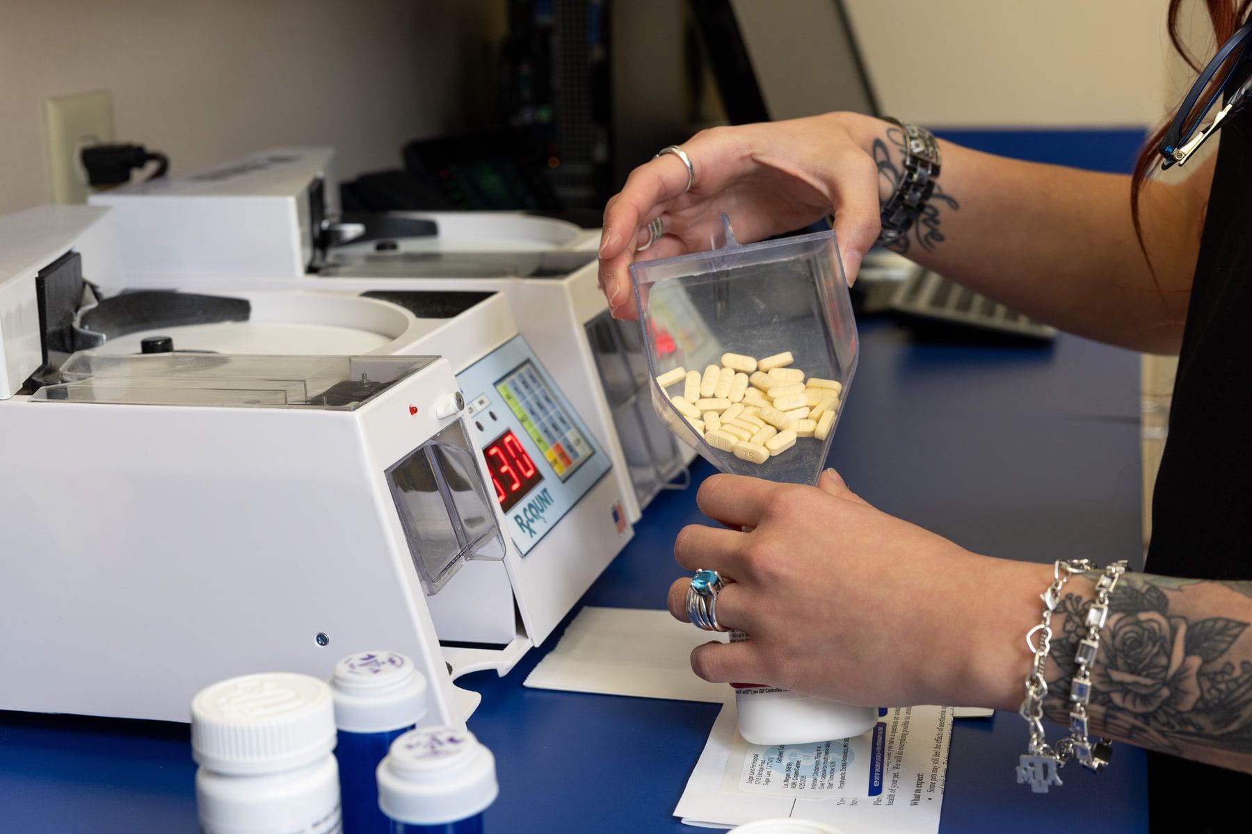 Close-up of a staff member counting tablets at the on-site pharmacy