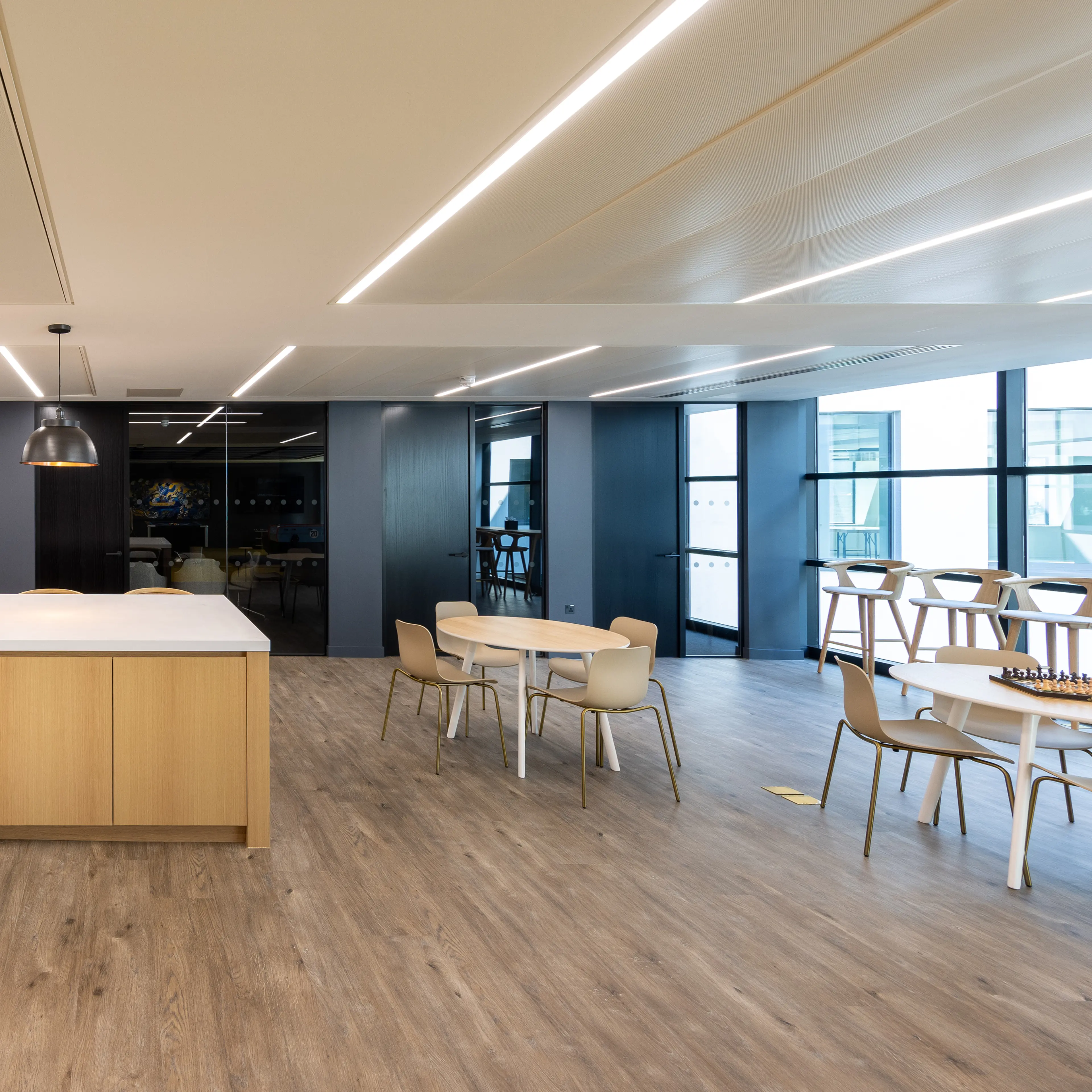 Modern office space with collaborative seating and linear ceiling lights, featuring text: 'What is retrofit and why does it matter?'