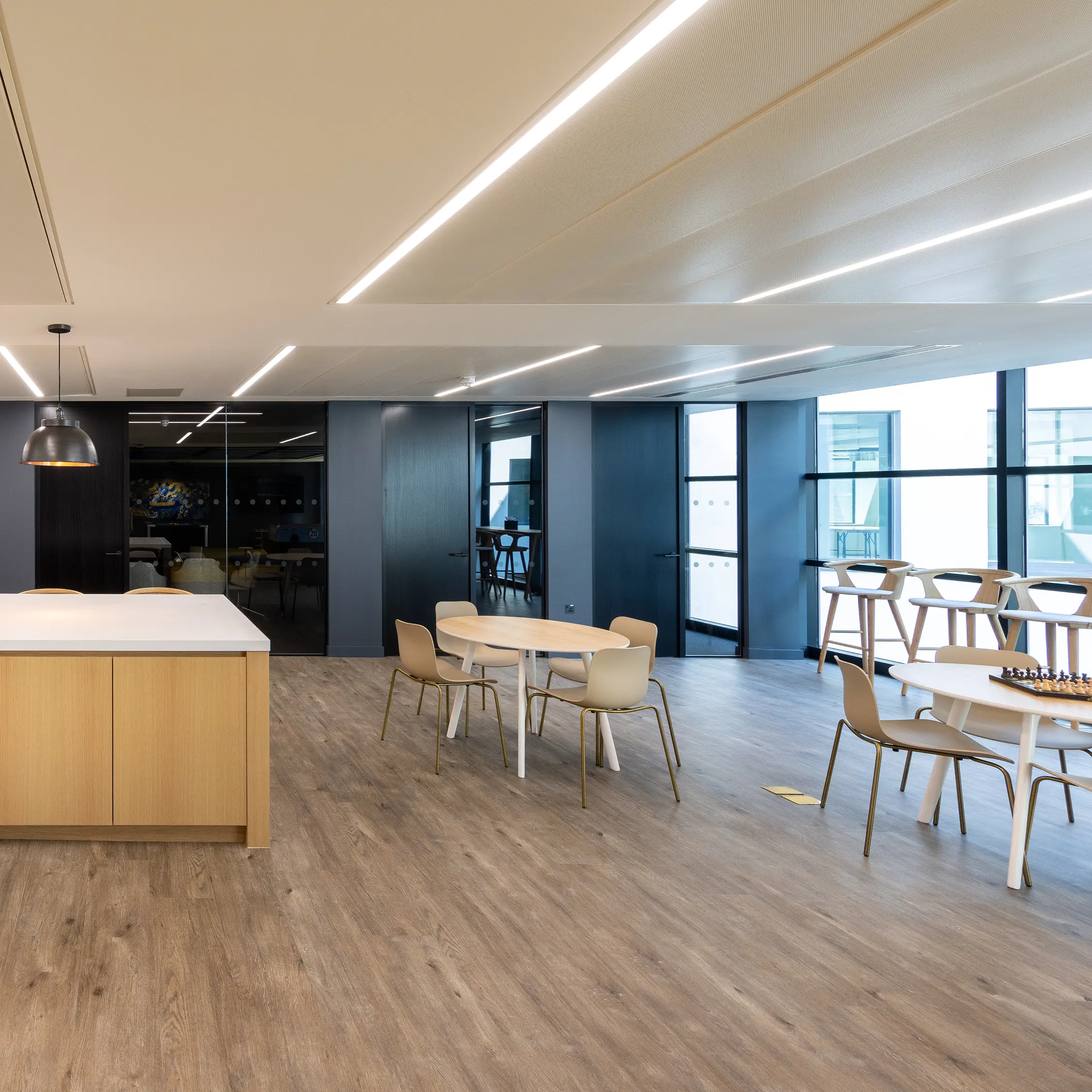 Modern office space with collaborative seating and linear ceiling lights, featuring text: 'What is retrofit and why does it matter?'