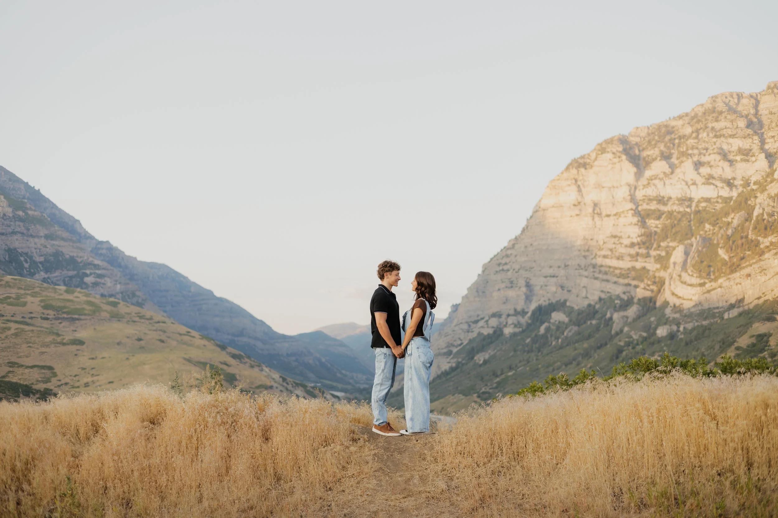 Couple standing together in a Utah mountain valley at golden hour