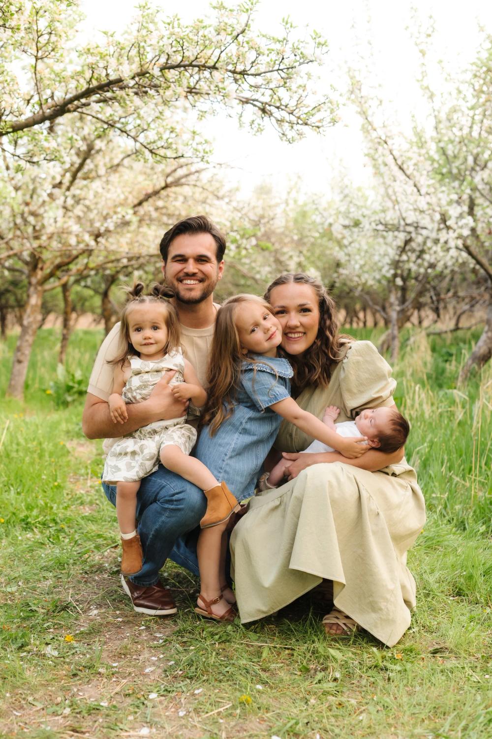 Bri Atkinson with her family in a blossoming orchard