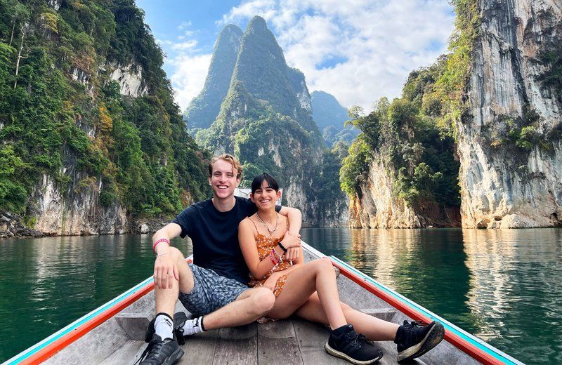 Couple sitting on front if Thailand long boat