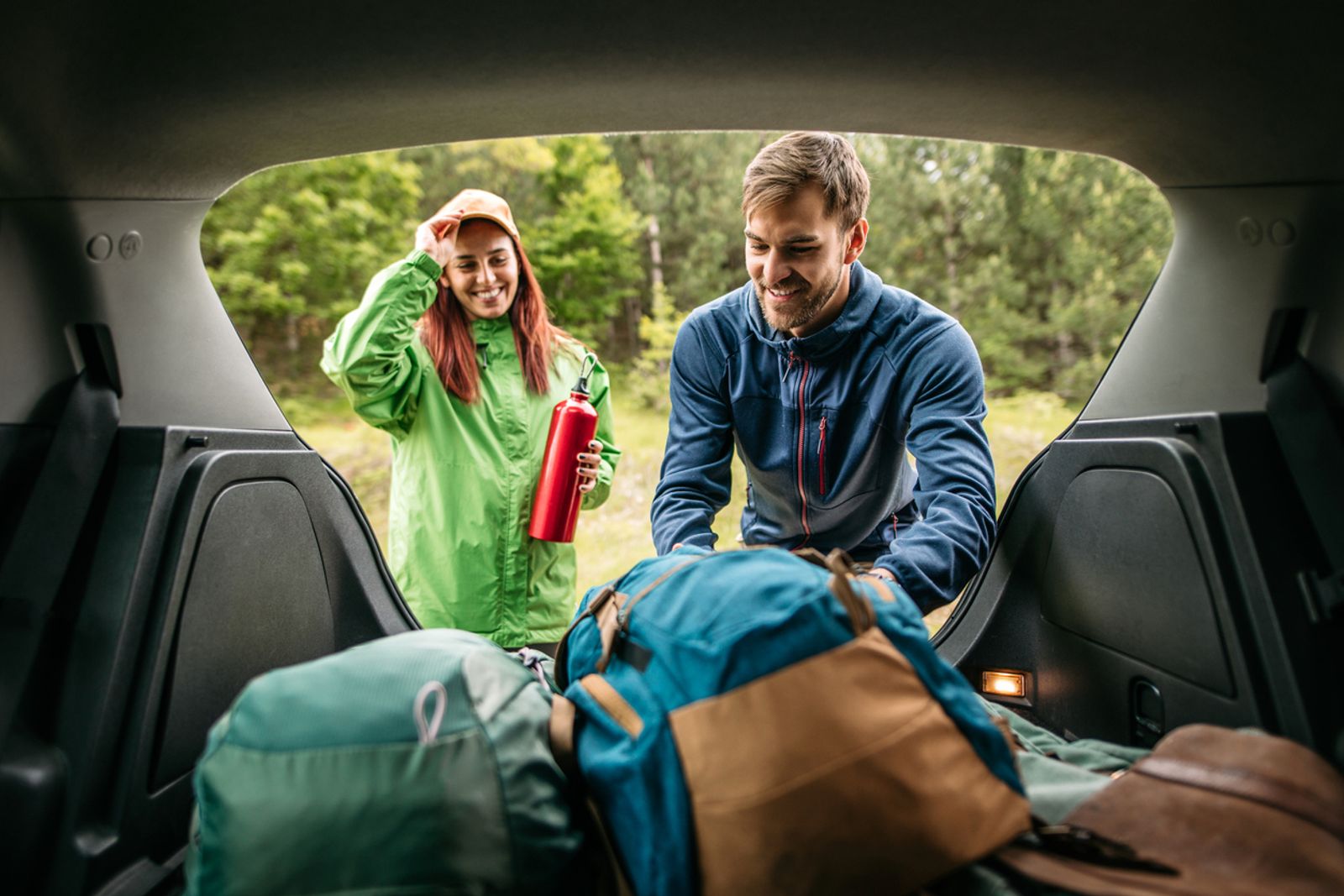 Et kjærestepar som er ute i skogen etter en langtur i bilen.