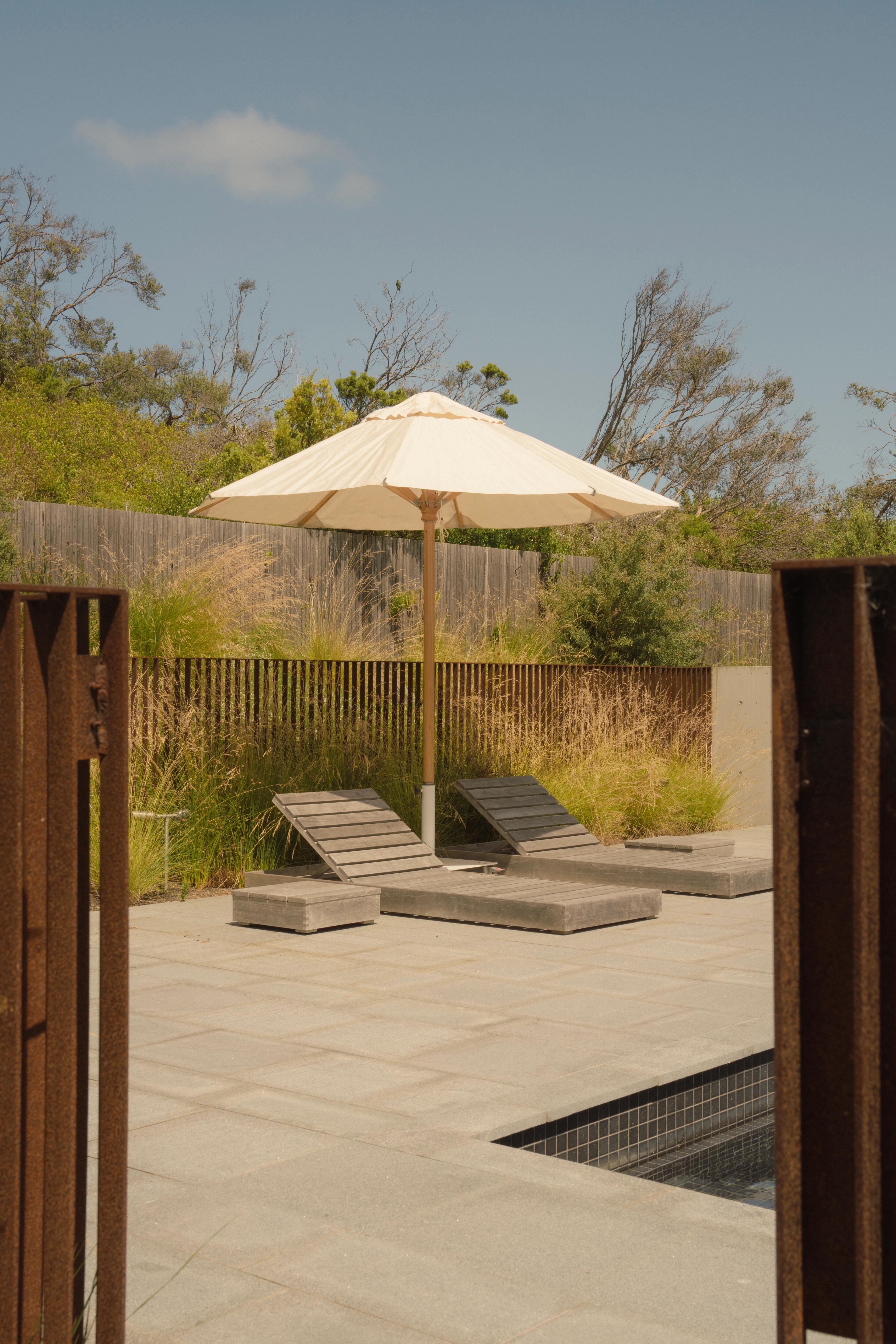 pool with umbrella and sunlounge