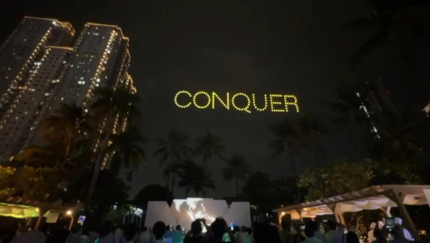 Drone light show spelling CONQUER in golden yellow letters over Shangrila Hotel Jakarta for Pertamina Lubricant National Distributor Summit 2026