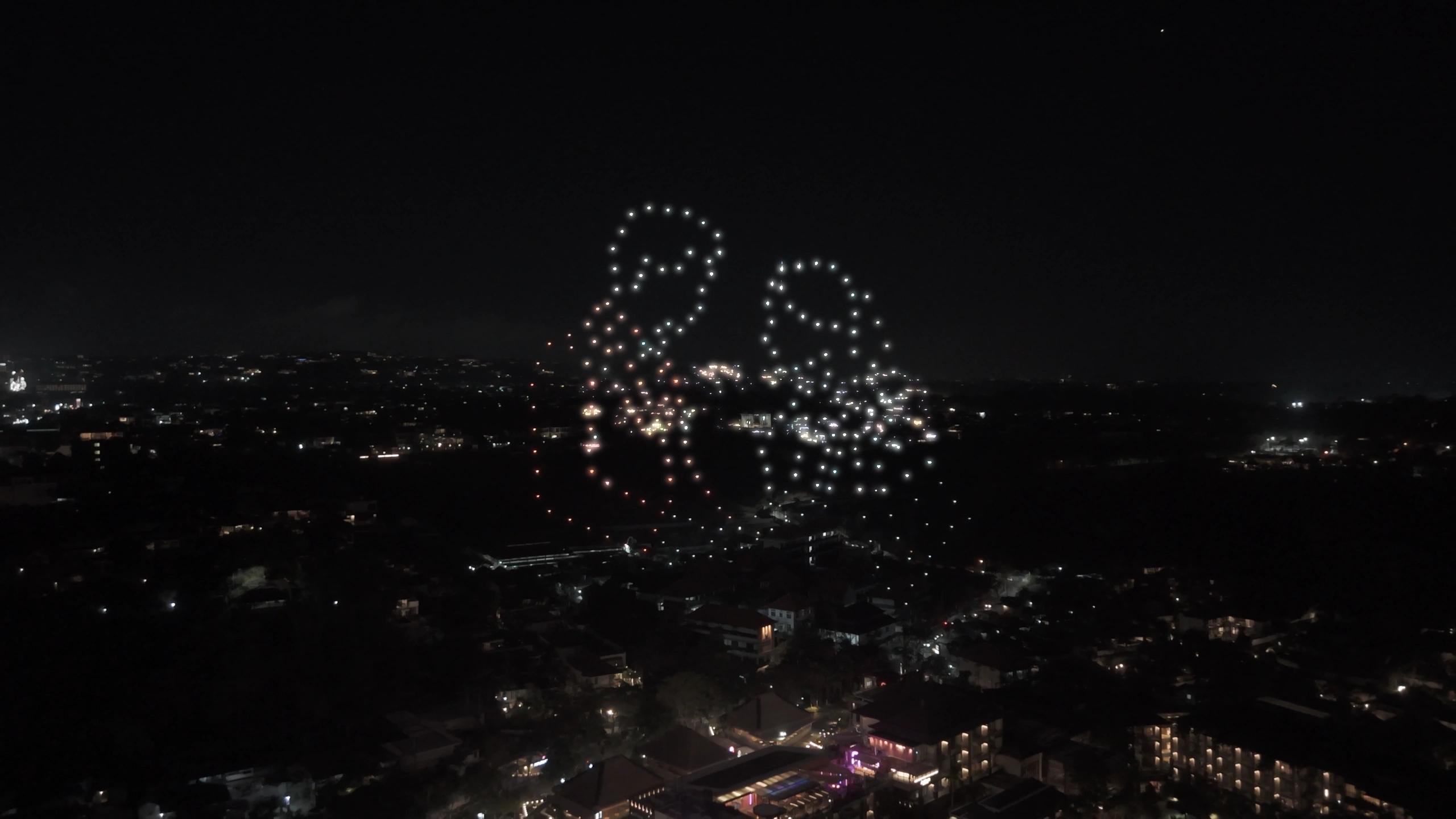 Dua siluet figur dari cahaya drone di langit Jimbaran pada grand opening Suwarga Garden.