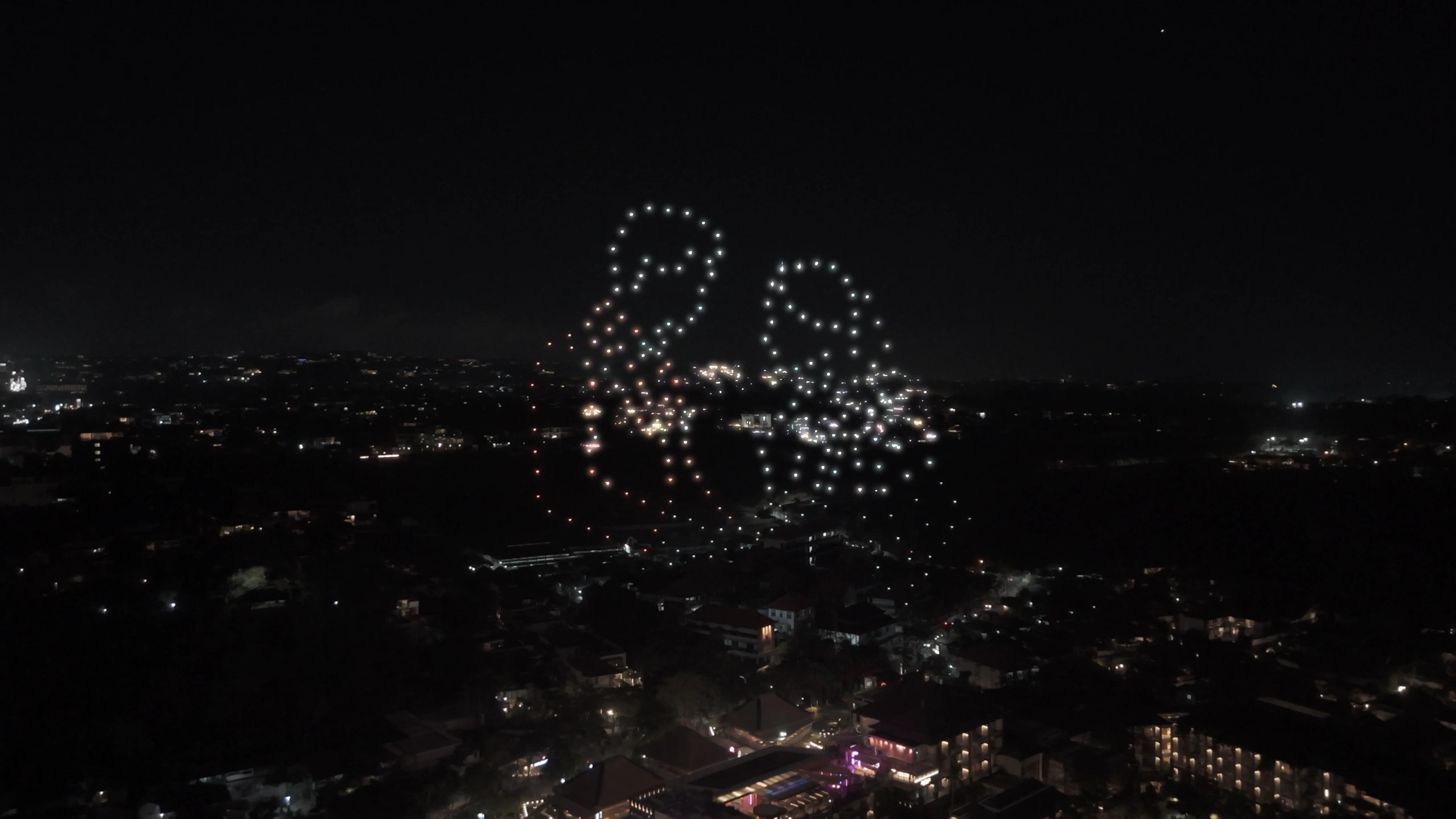 Dua siluet figur dari cahaya drone di langit Jimbaran pada grand opening Suwarga Garden.