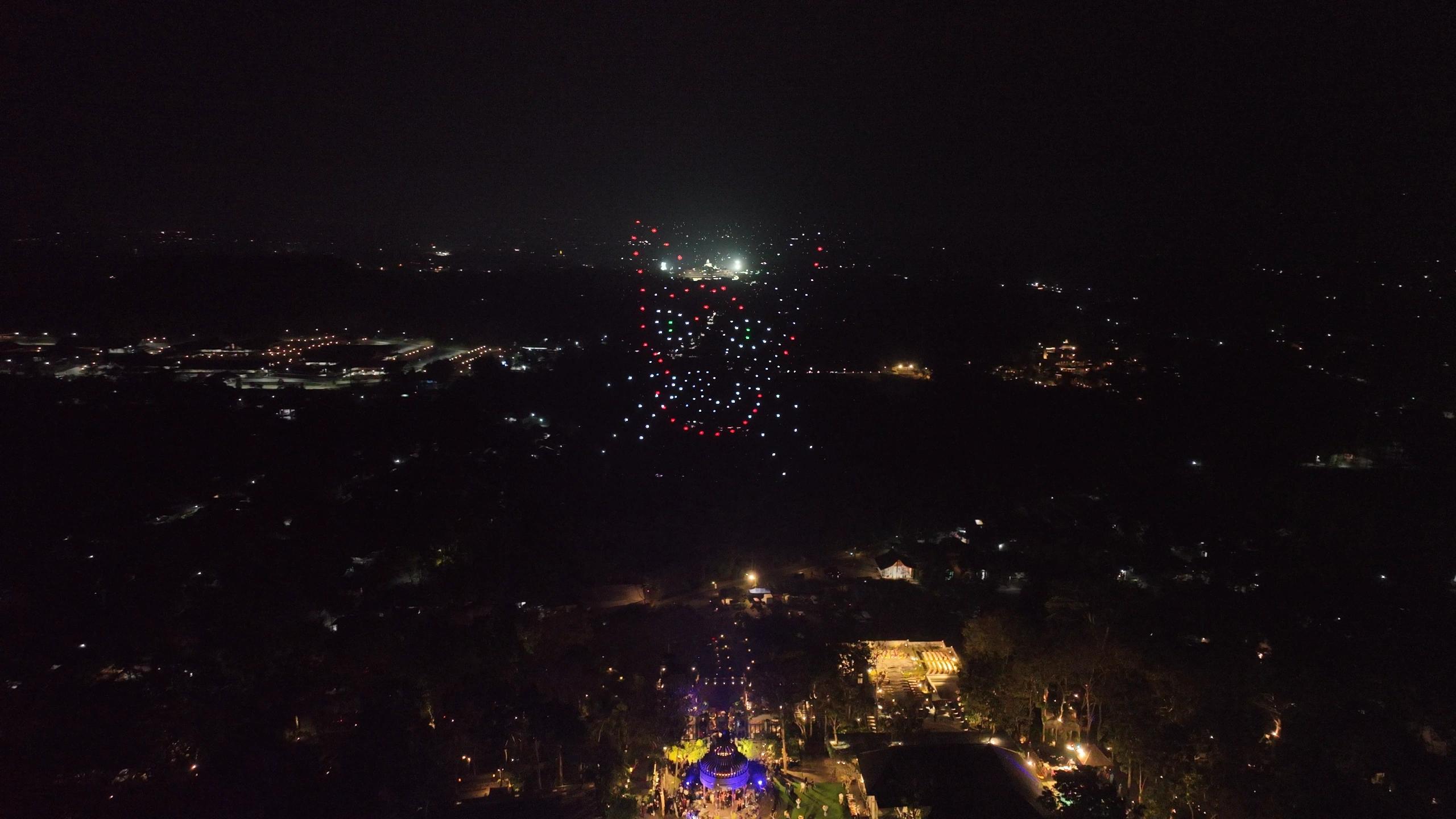 Formasi wajah kucing kedua dengan aksen cahaya merah, putih, dan hijau di langit malam.