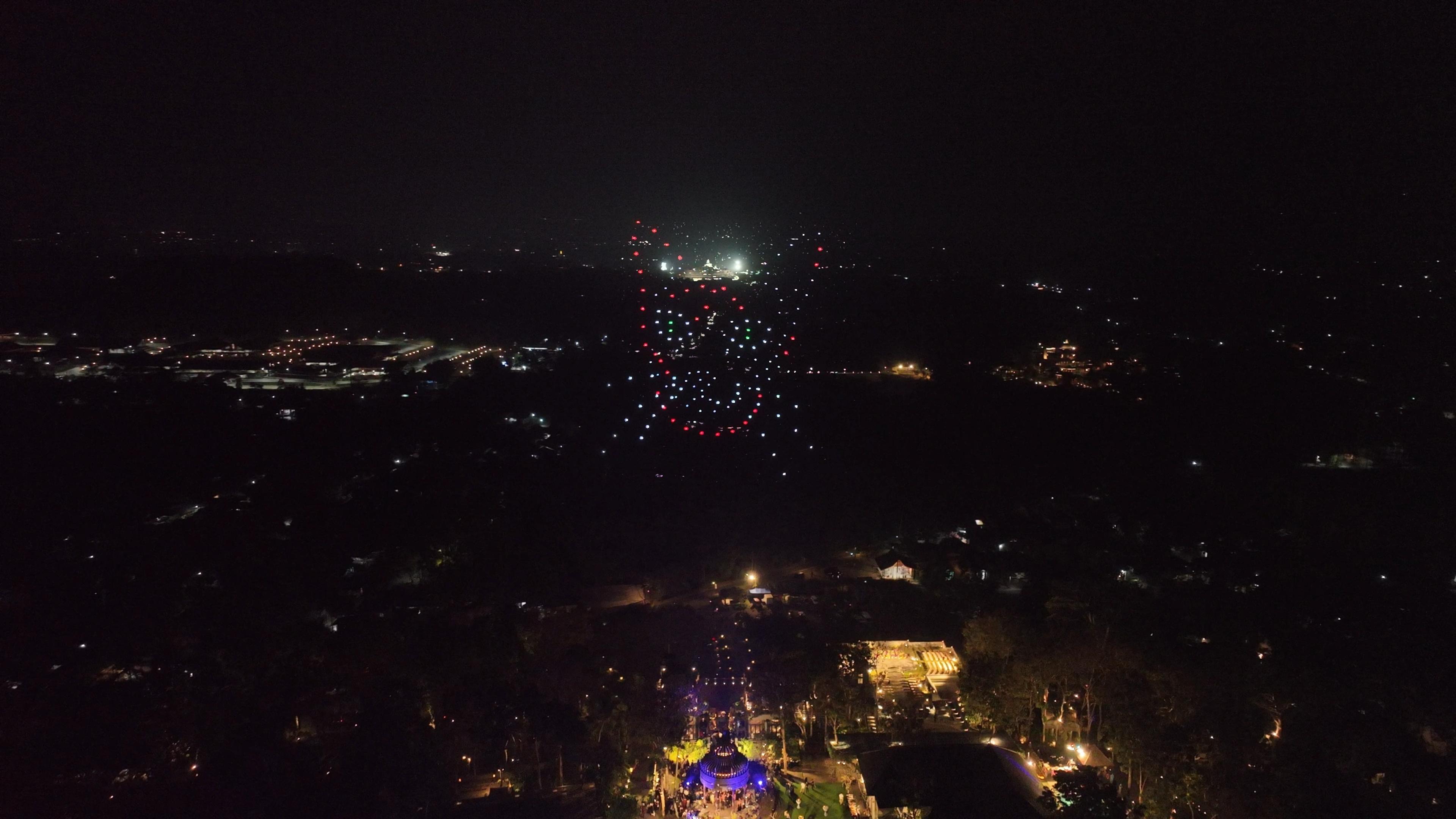 Formasi wajah kucing kedua dengan aksen cahaya merah, putih, dan hijau di langit malam.