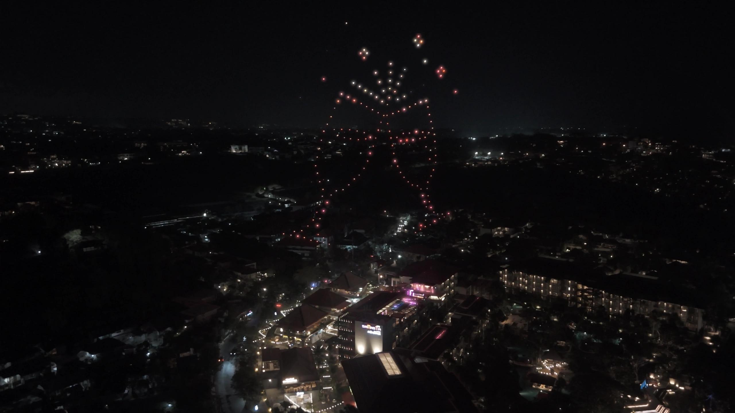 Dua gelas bersulang dari cahaya drone di atas Mövenpick Resort & Spa Jimbaran Bali.