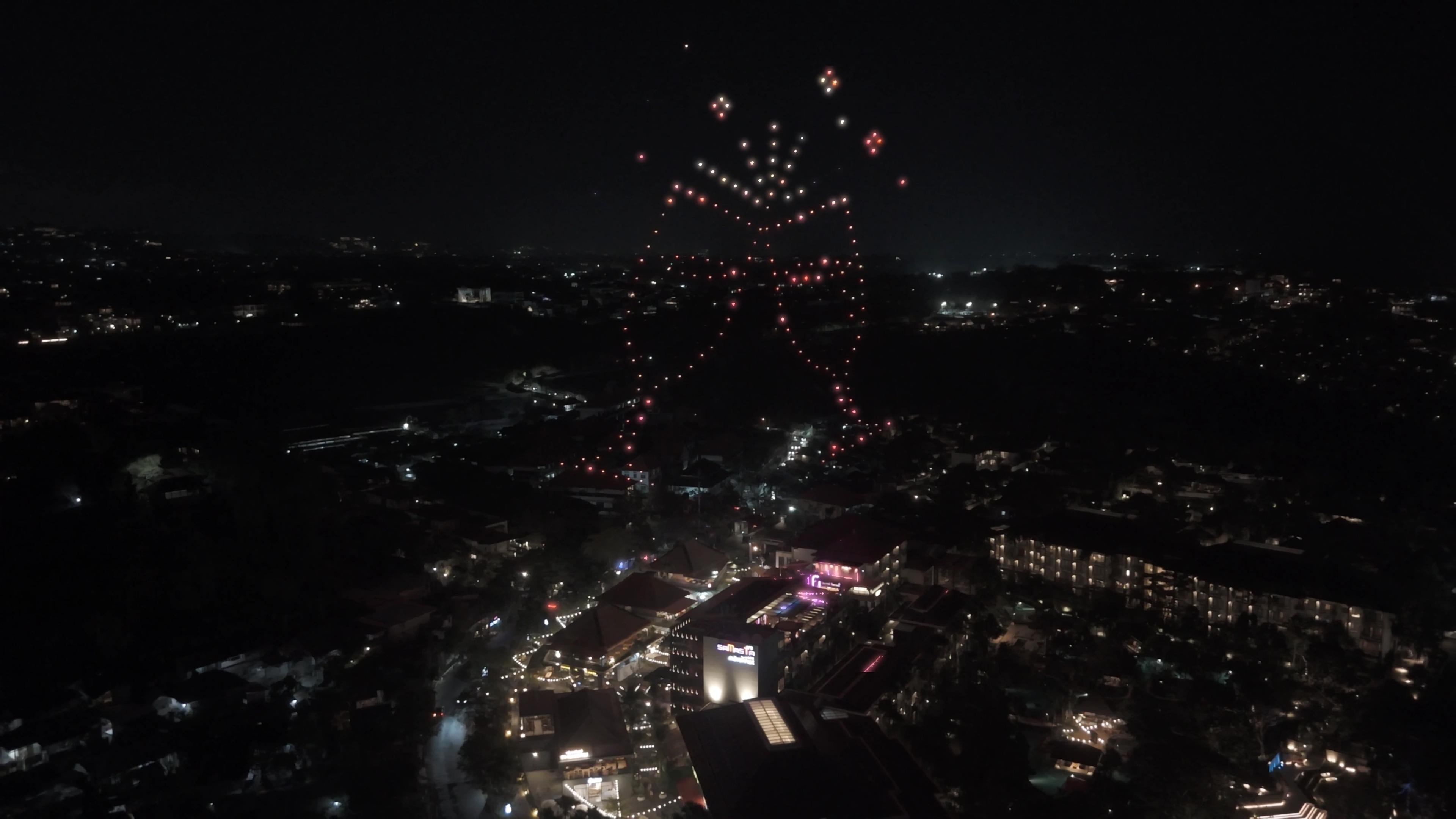 Dua gelas bersulang dari cahaya drone di atas Mövenpick Resort & Spa Jimbaran Bali.