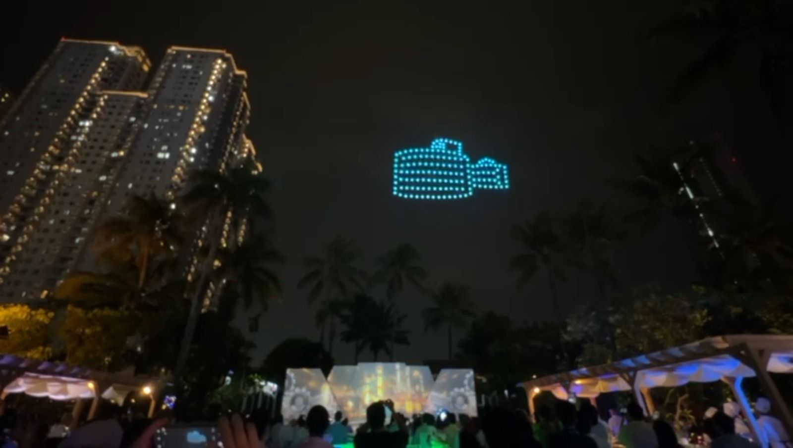 150 drones create an oil refinery (kilang minyak) formation in cyan-blue lights above Jakarta skyline symbolising Pertamina's core business at NDS 2026