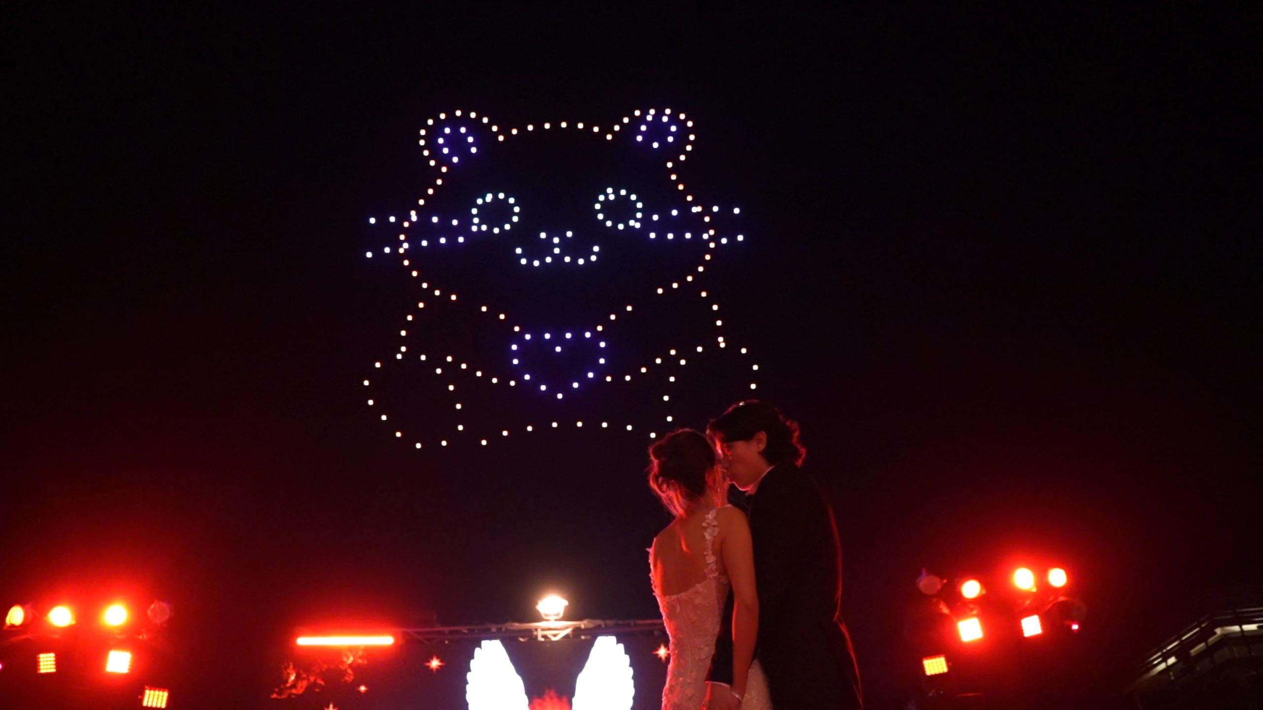 Christina and Andrew beneath a bear-shaped drone formation at their Alila Villas Uluwatu wedding.