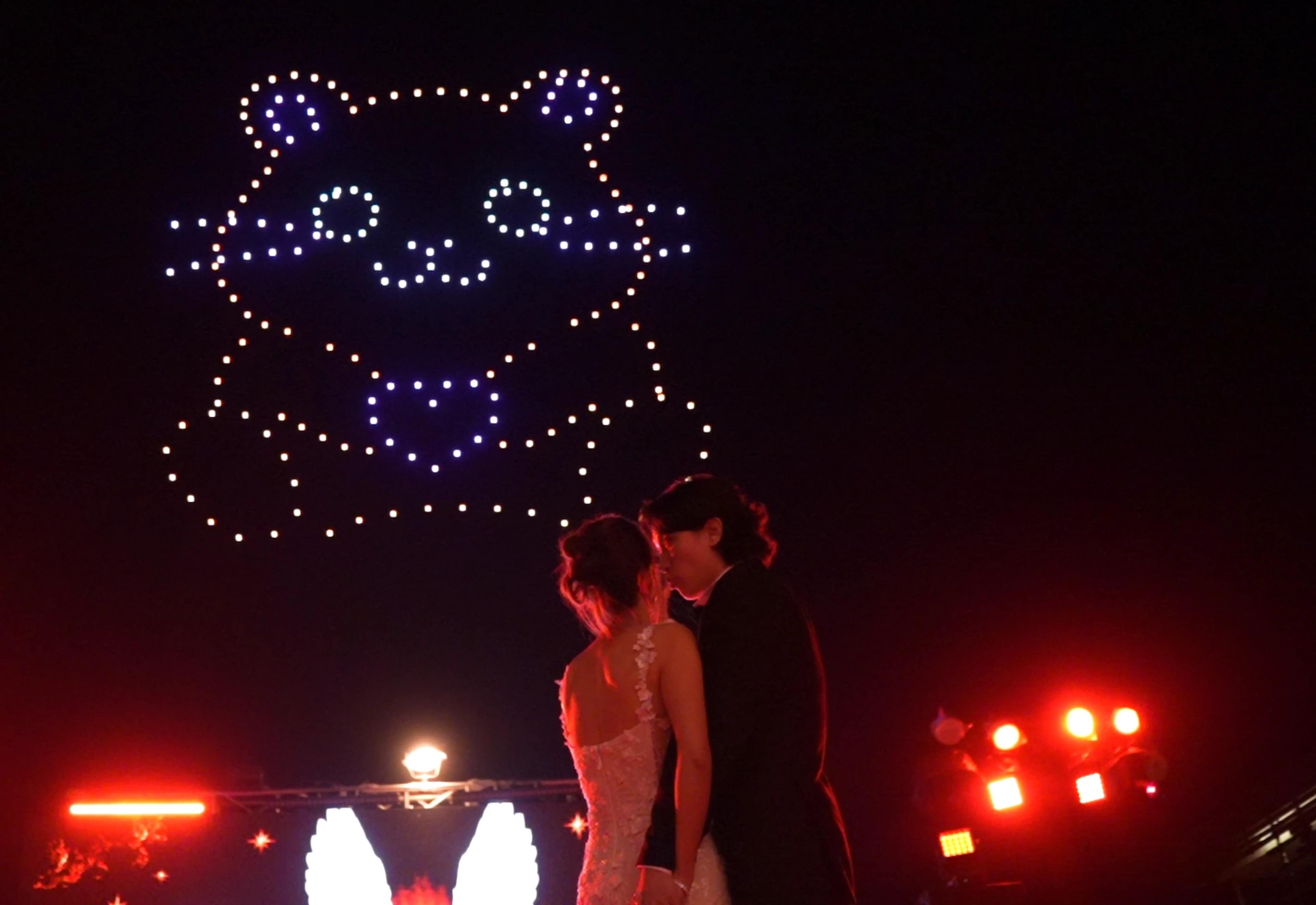 Christina and Andrew beneath a bear-shaped drone formation at their Alila Villas Uluwatu wedding.