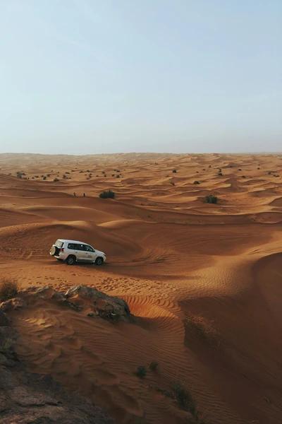 4x4 car racing through the sand dunes of the Arabian desert